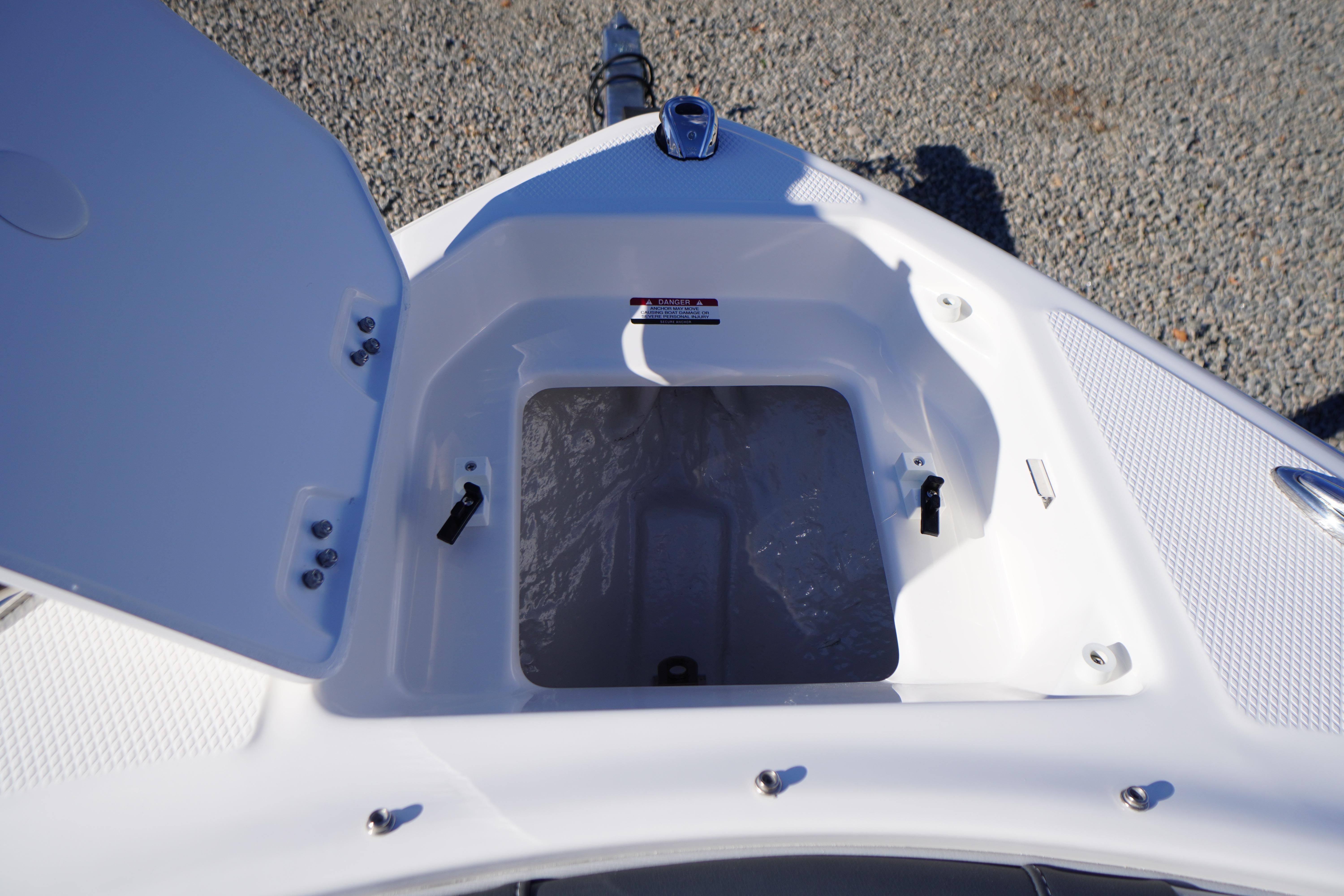 Open storage compartment on 2026 Chaparral 23 SSi boat, showing interior details.