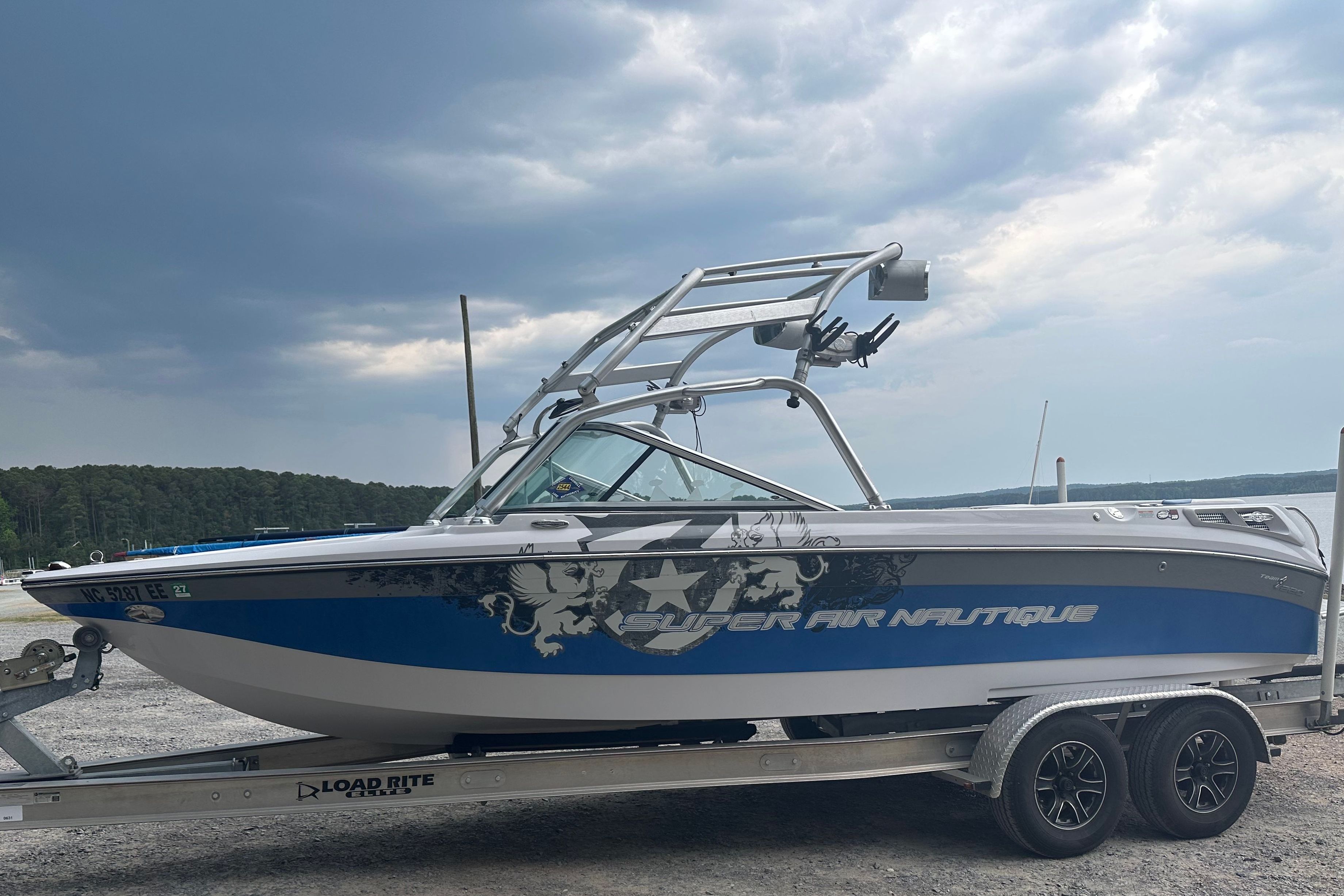 2008 Nautique Super Air Nautique 220 on trailer, cloudy sky.