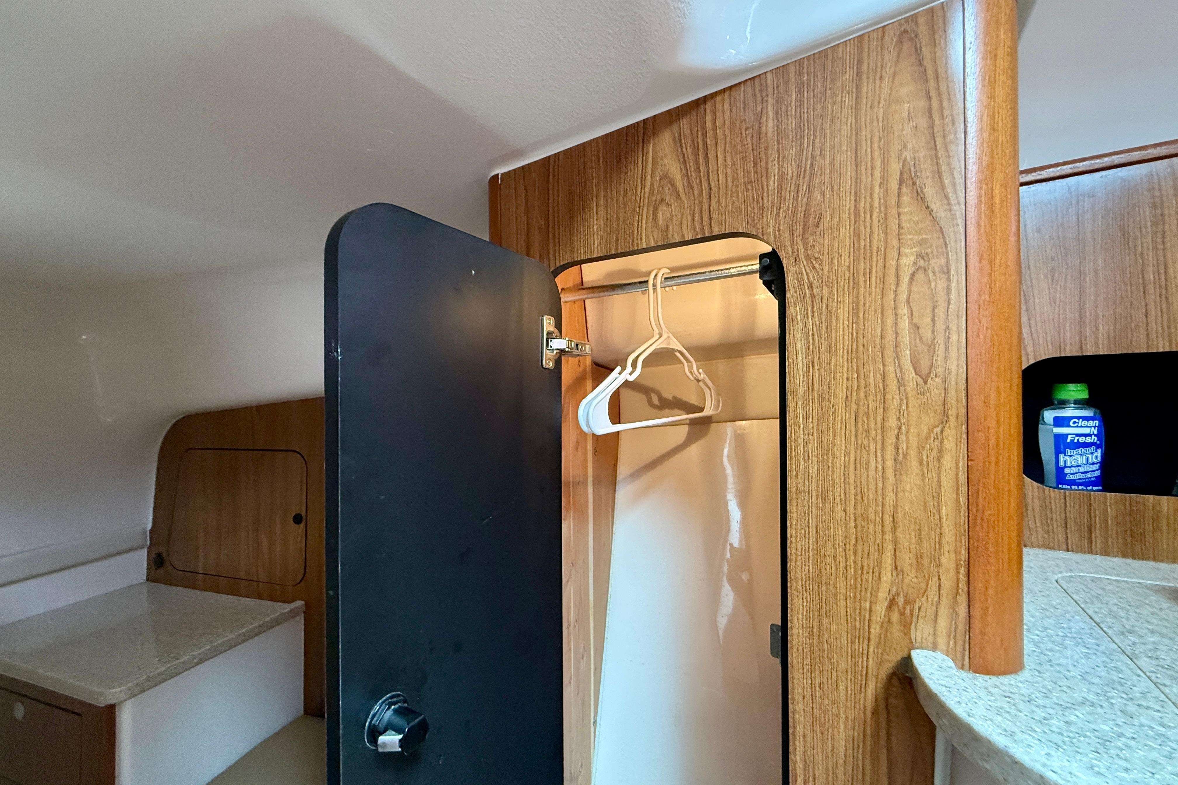 Interior of 2012 Pursuit OS 345 Offshore boat with wooden cabinetry and closet space.