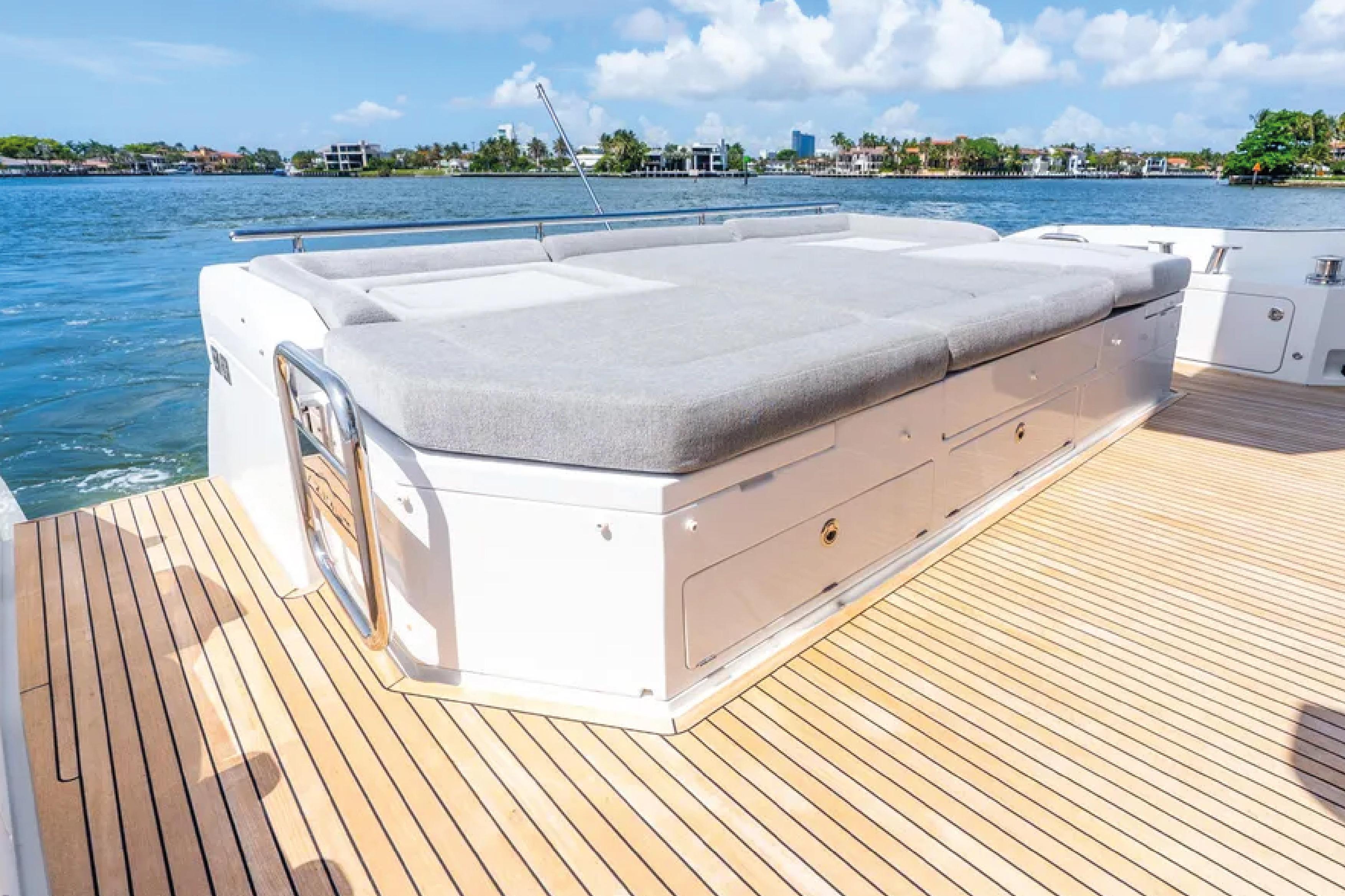 2019 Azimut S7 yacht deck with sunbed, overlooking serene waterfront.