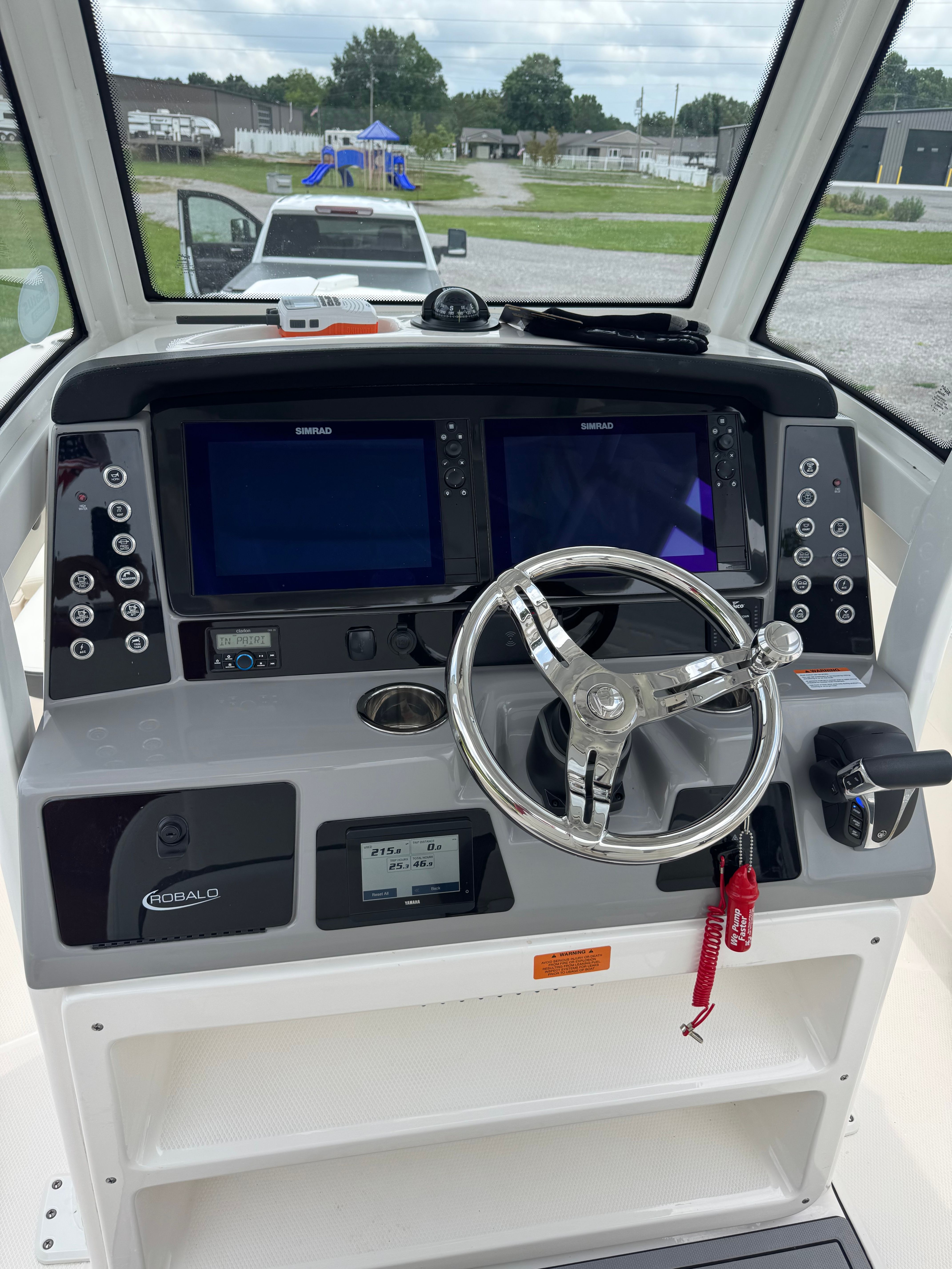 The image shows the helm of a 2023 Robalo 266 Cayman with dual screens and a steering wheel.