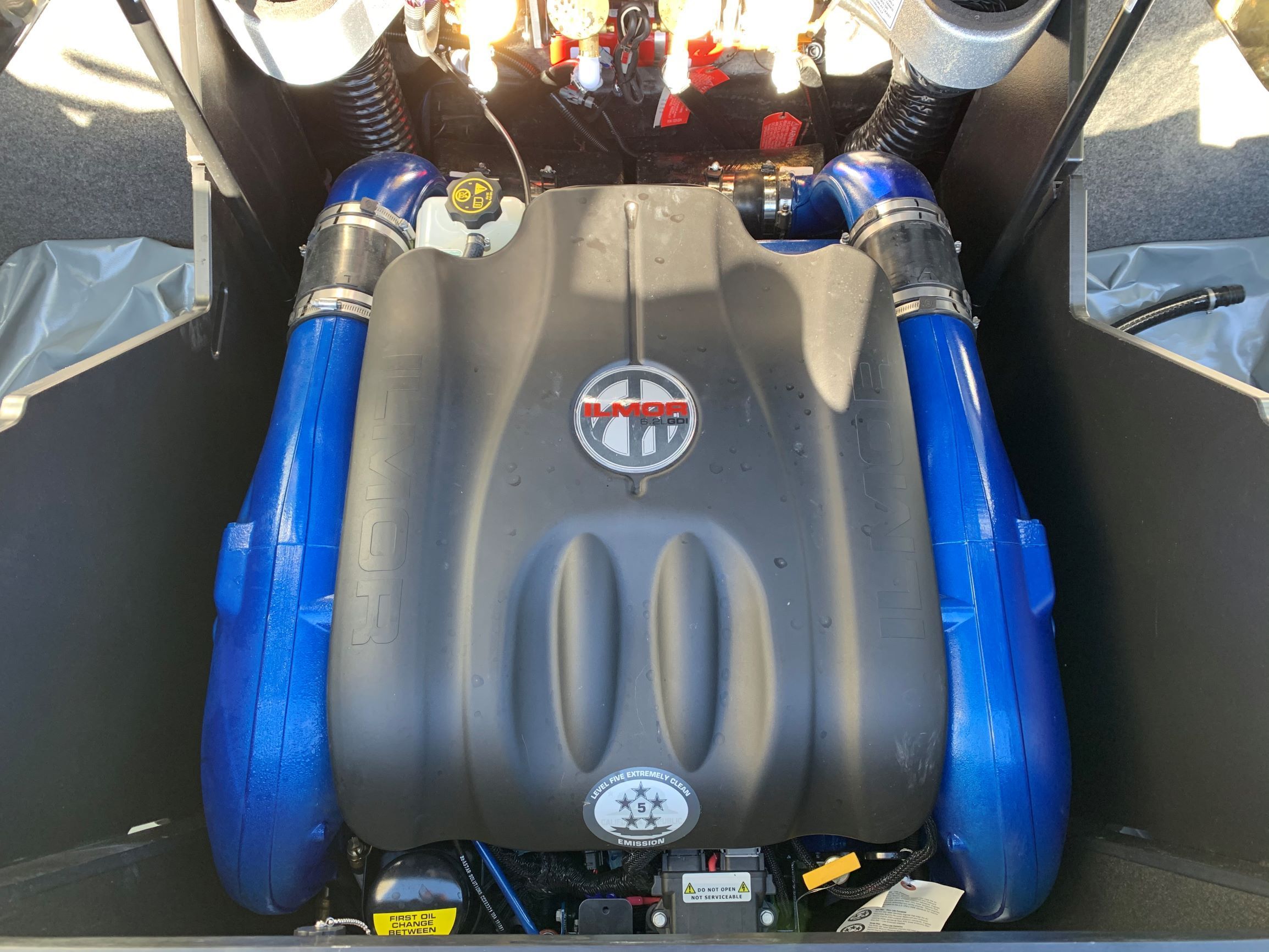 Engine compartment of a MasterCraft X24 boat with a large engine and blue components.