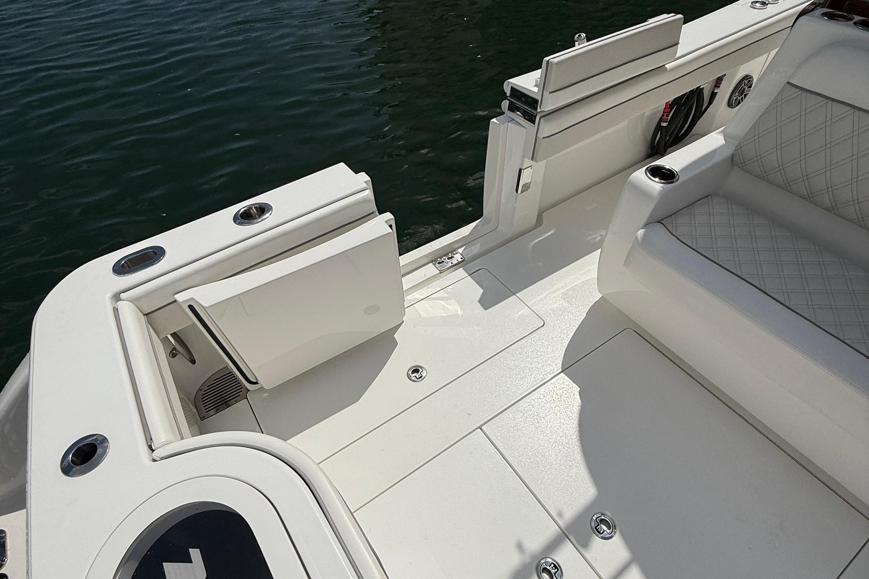 2024 Valhalla Boatworks V-37 deck with seating and cup holders by the water.