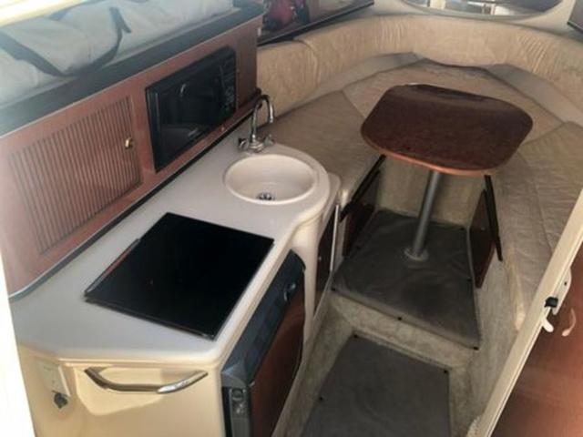 Interior of 2003 Sea Ray 260 Sundancer with kitchenette and seating area.