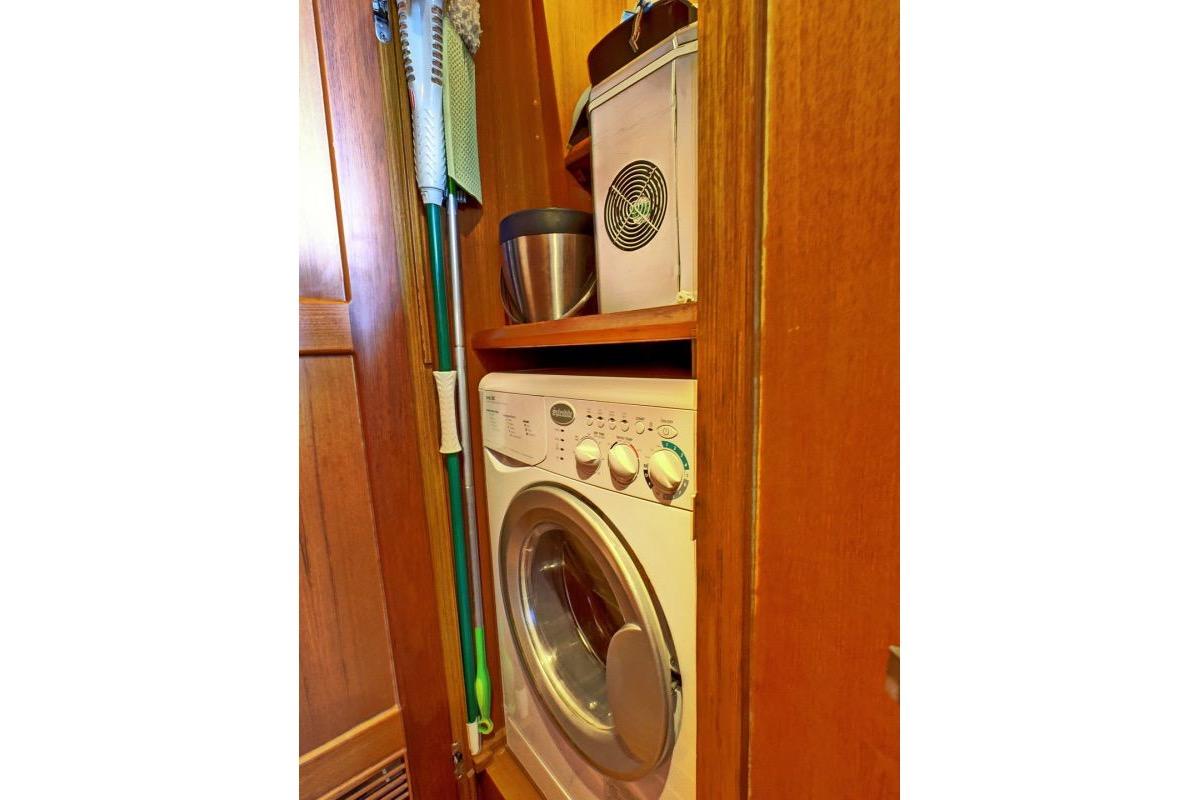Laundry area in 2016 North Pacific 45 Pilothouse with washer and cleaning supplies.