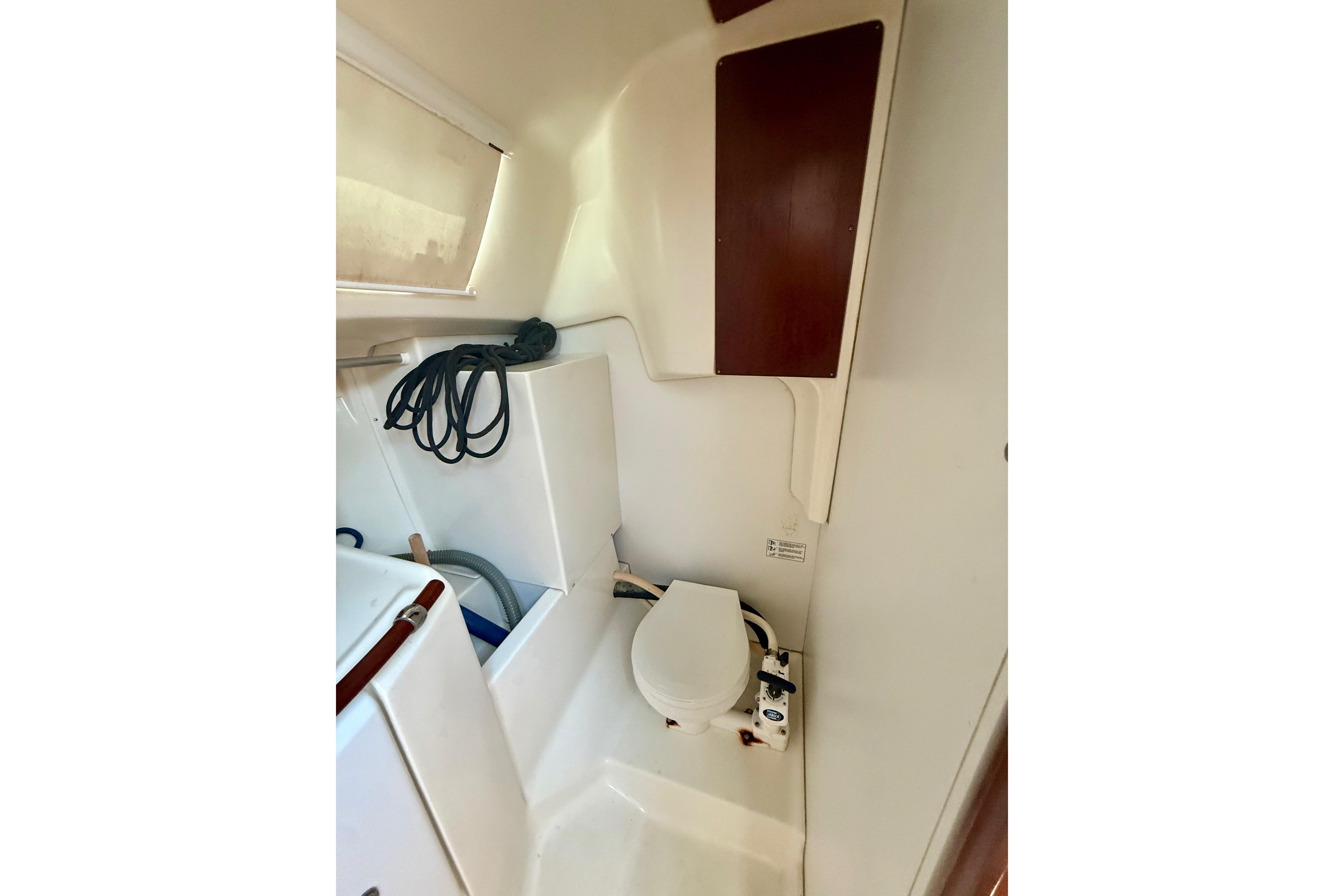 Interior of 2002 Beneteau Oceanis Clipper 311 yacht bathroom with toilet and storage.