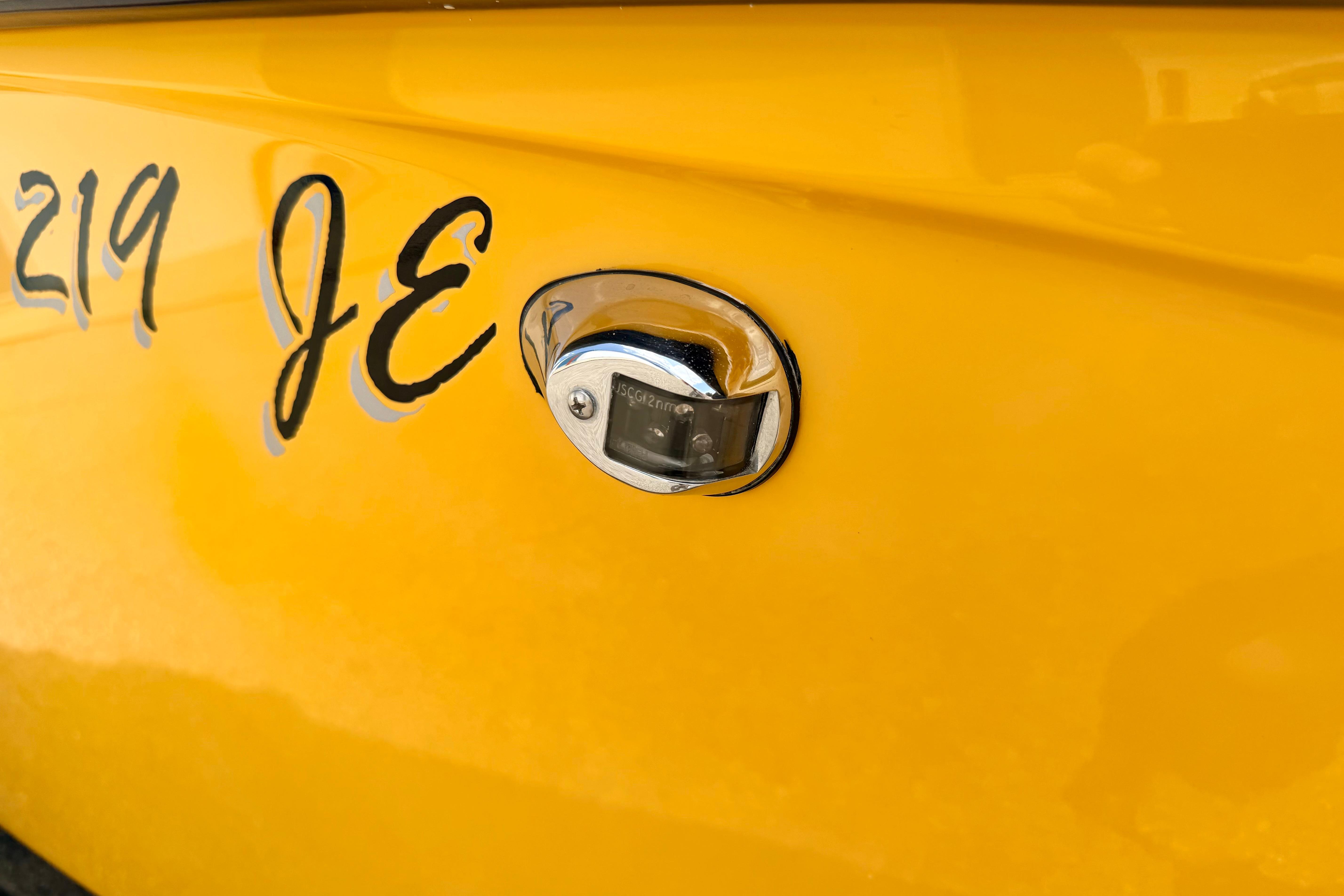 Close-up of a yellow 2014 Tigé R20 boat with chrome detailing and lettering.