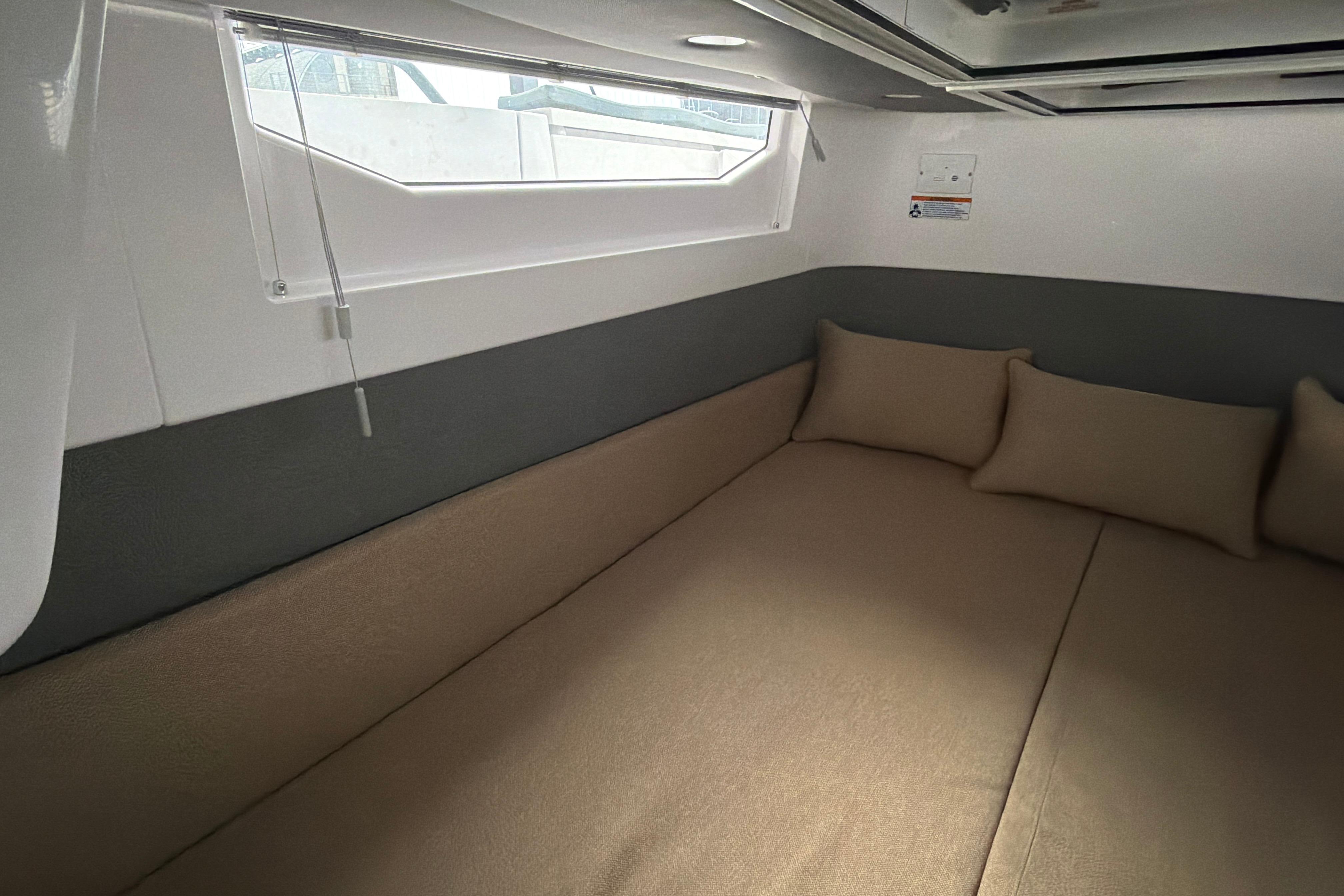 Interior cabin of 2022 Axopar Brabus 37 XC Cross Cabin with beige cushions.