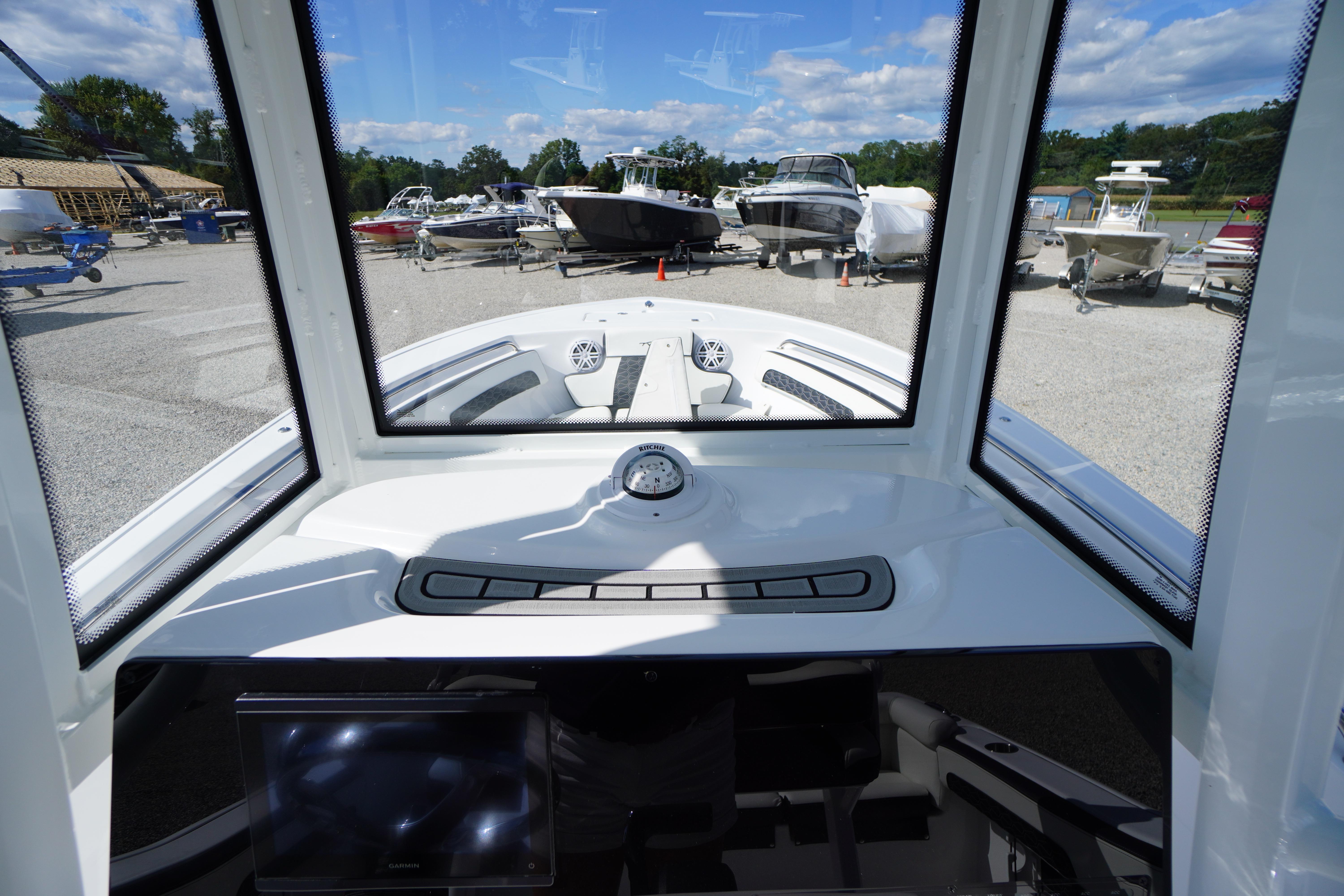 2026 Tidewater 220 LXF boat dashboard view with marina background.