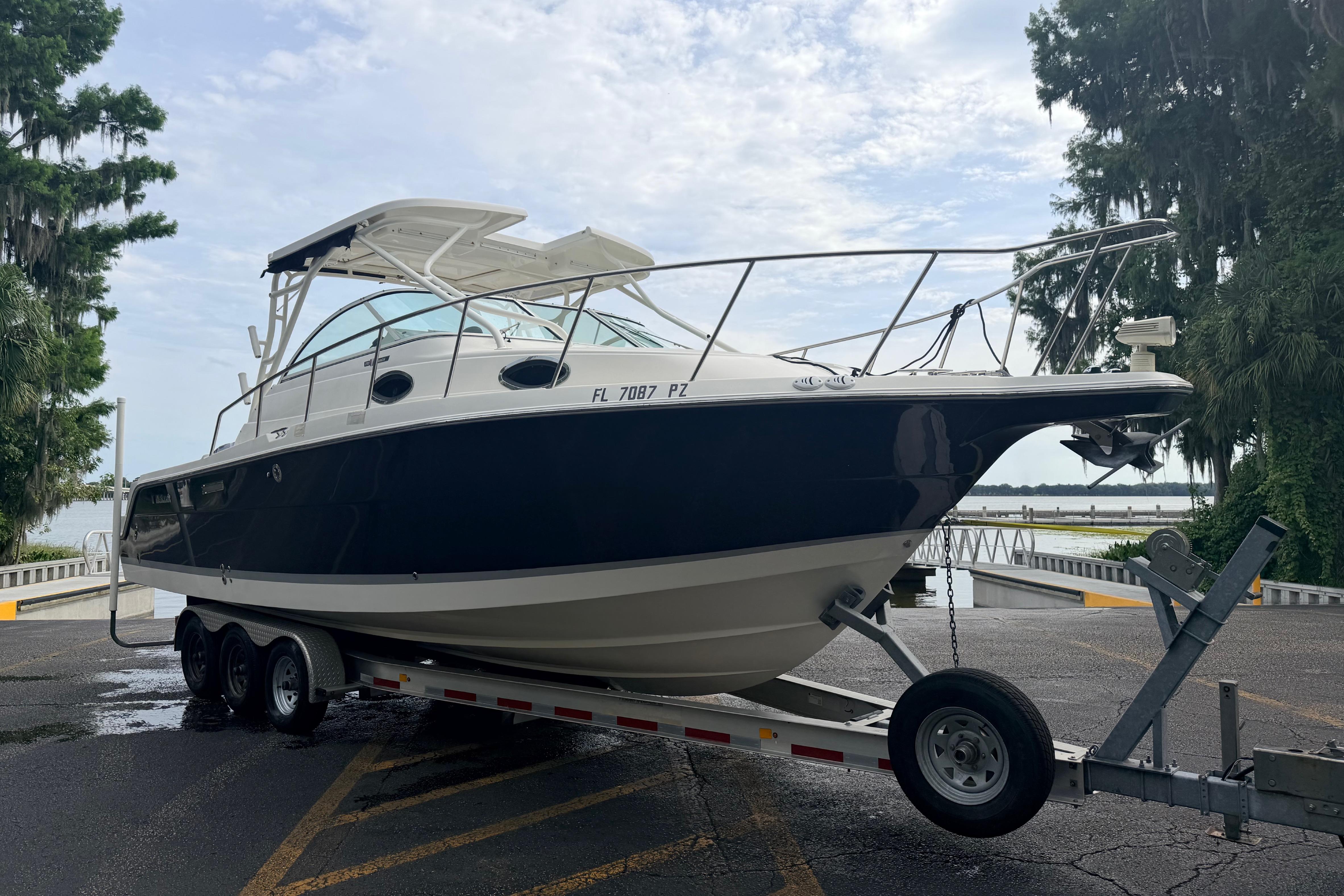 2015 Wellcraft 290 Coastal boat on trailer near waterfront.