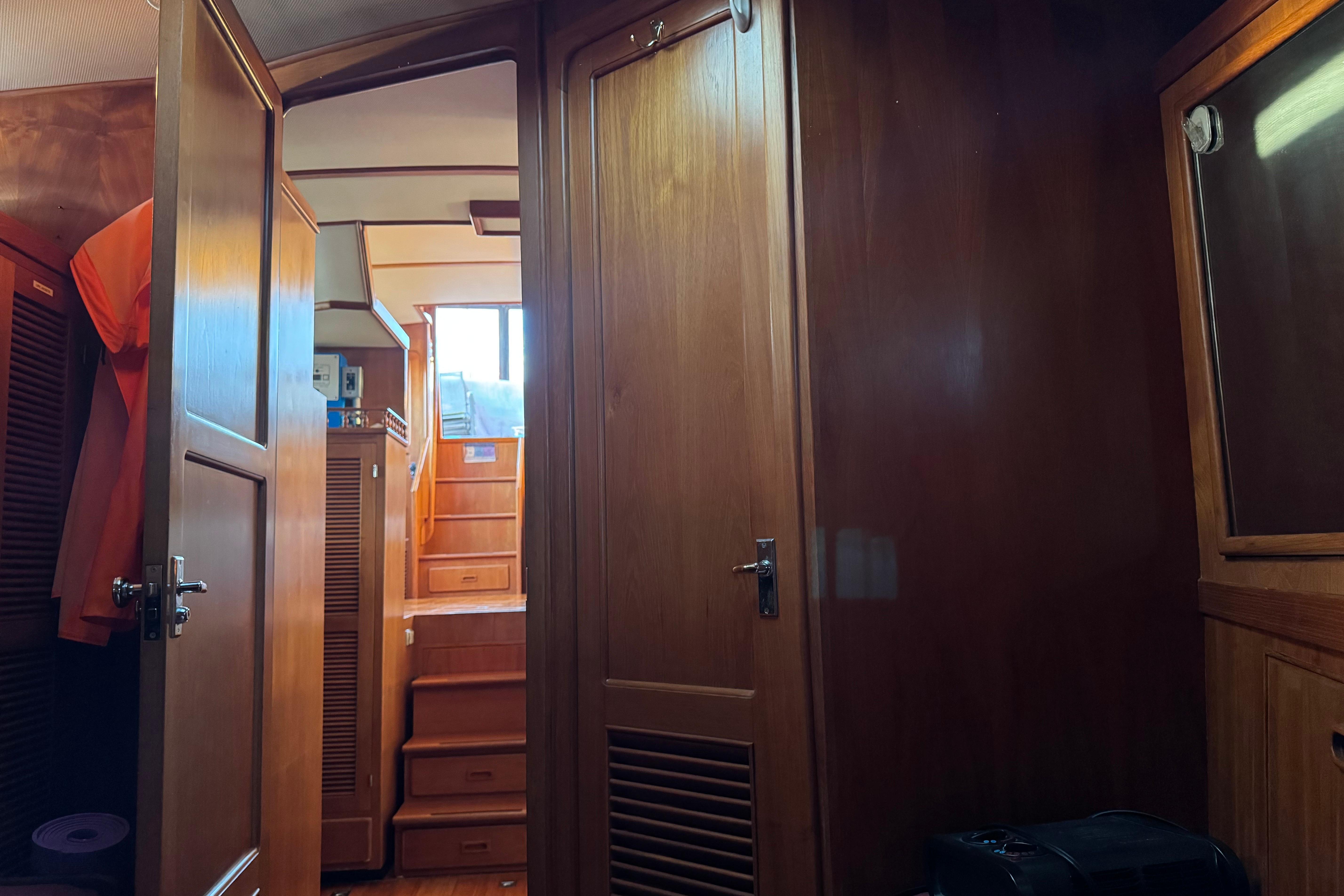 Interior of a 1987 President 37 yacht with wooden paneling and stairs.