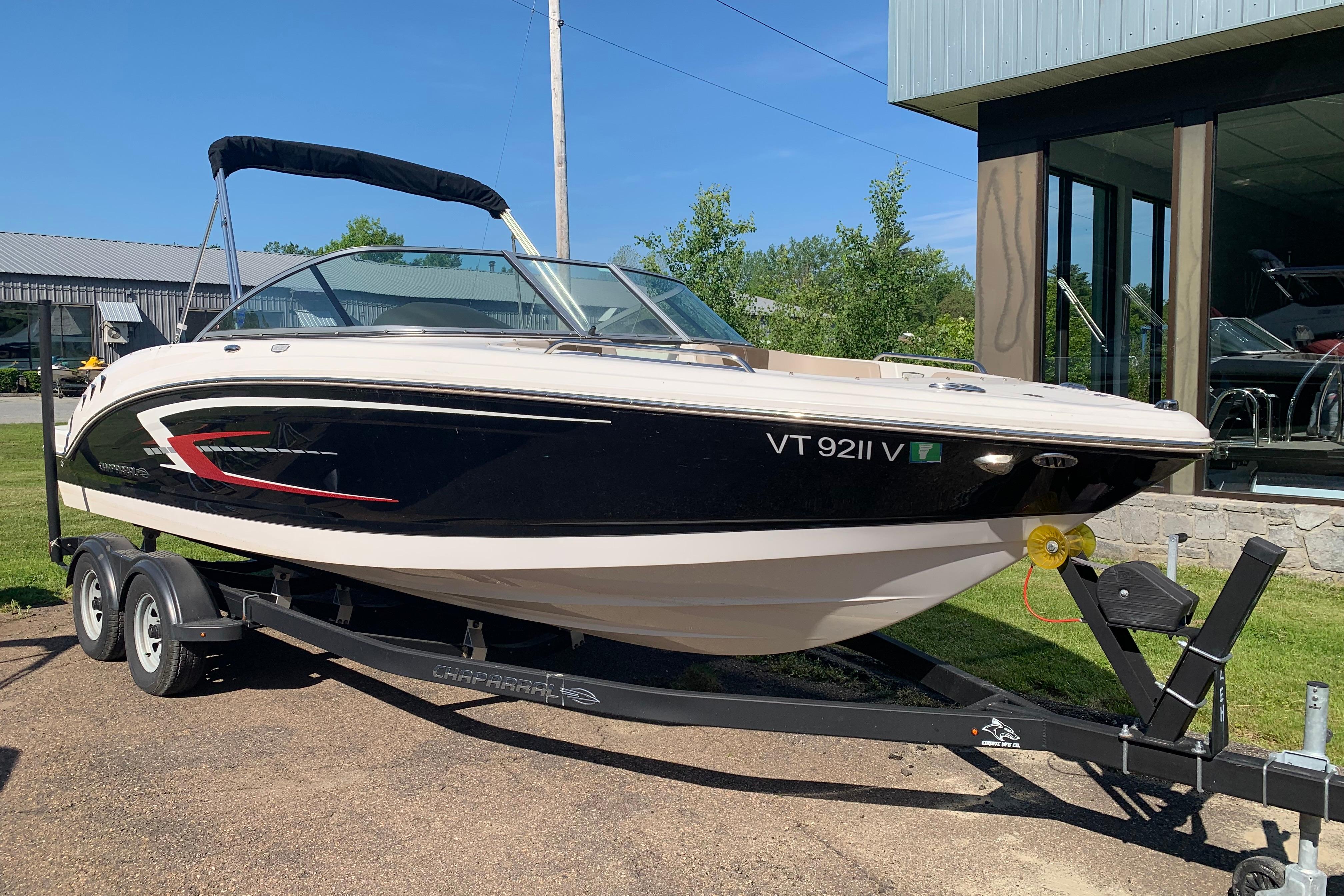 2022 Chaparral 23 SSi boat on trailer, parked outdoors near a building.