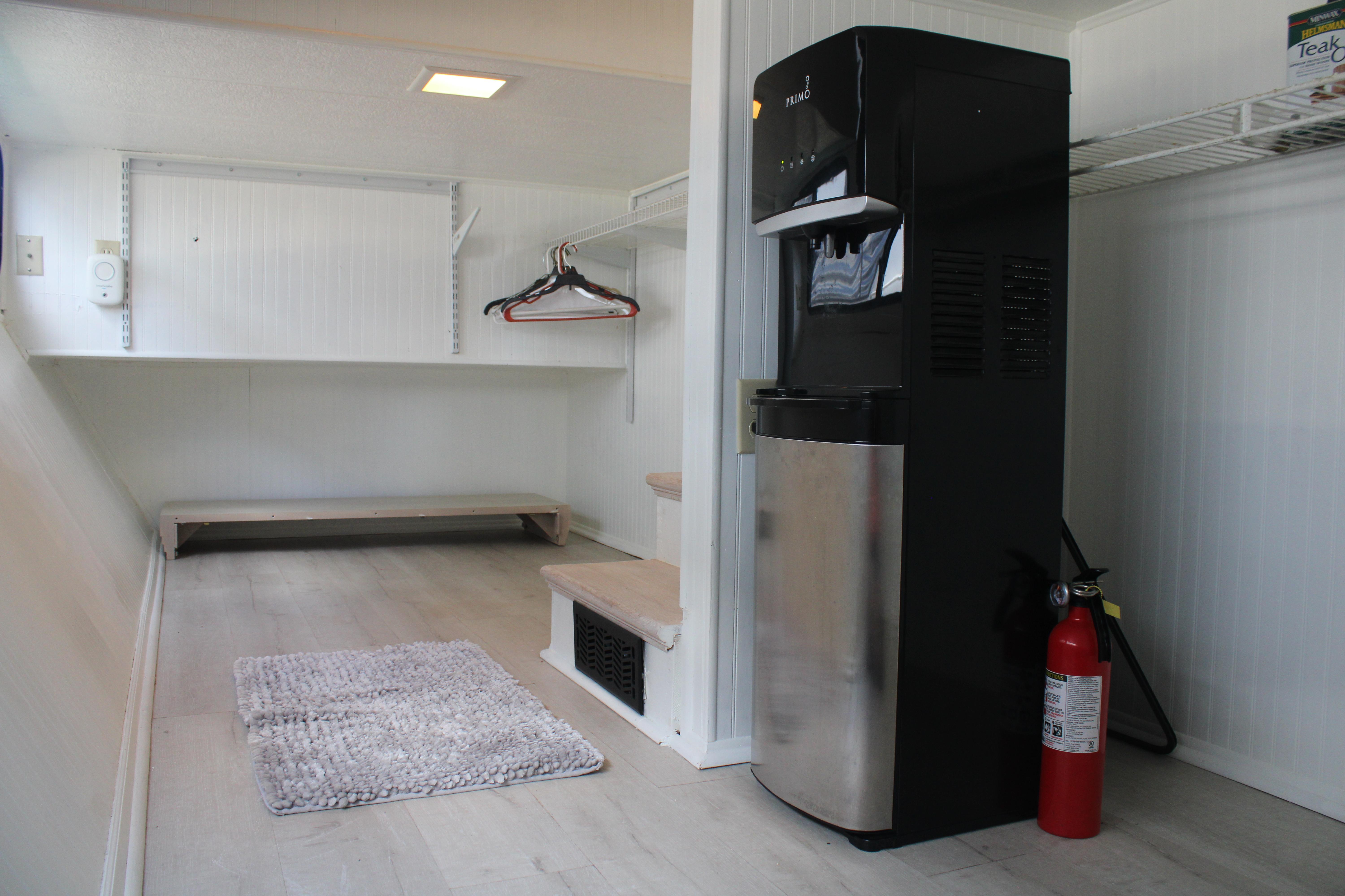 Laundry room in a 1992 Sumerset 66 houseboat with water dispenser and fire extinguisher.