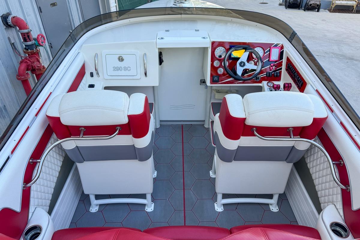 Interior of 2022 Velocity 290sc boat with red and white seating and modern dashboard.