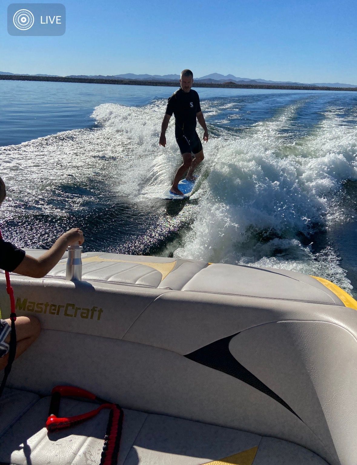 Man surfing behind a 2007 MasterCraft X-2 boat on a lake.