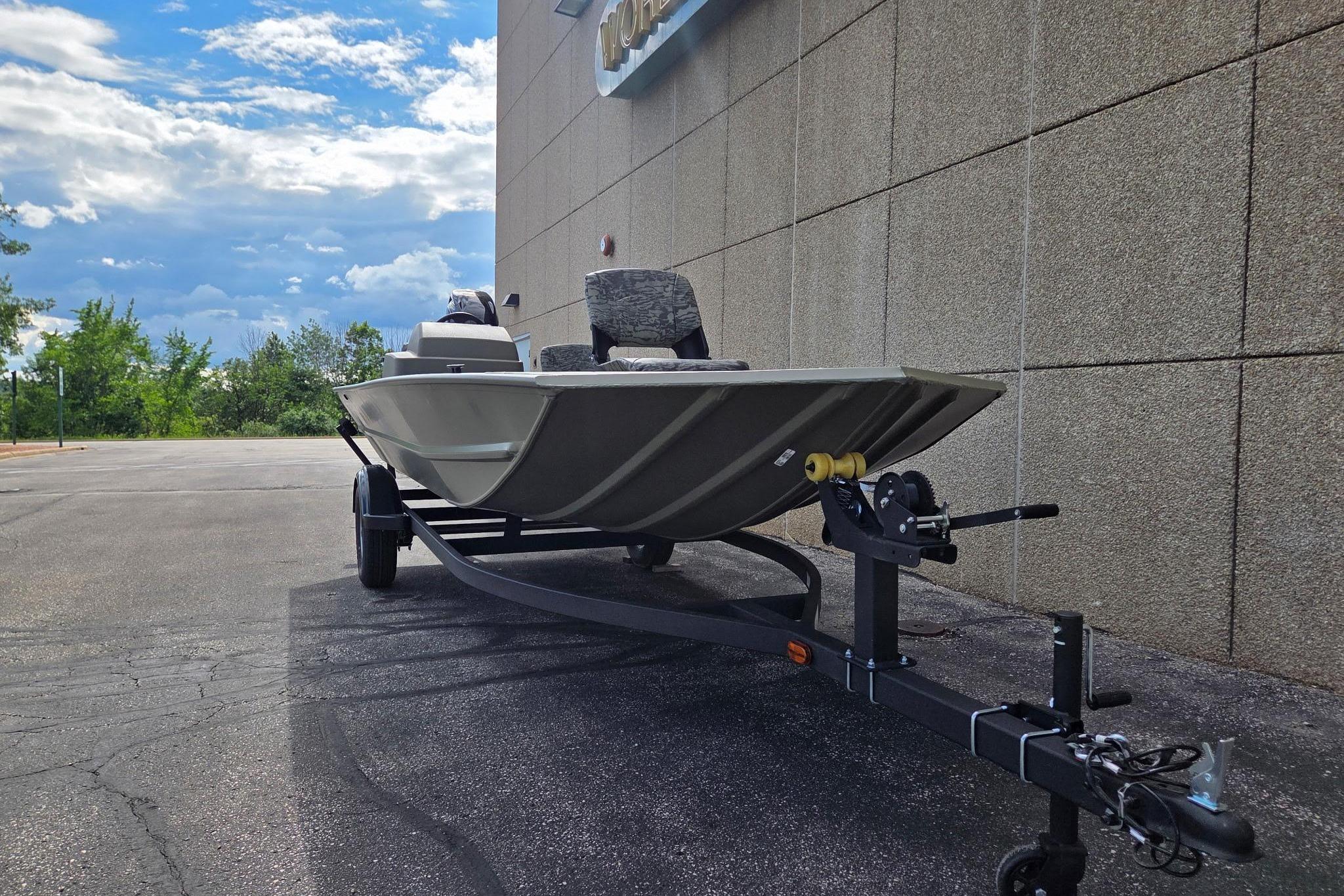 2026 Tracker Grizzly 1754 SC boat on trailer, parked outdoors near a building.