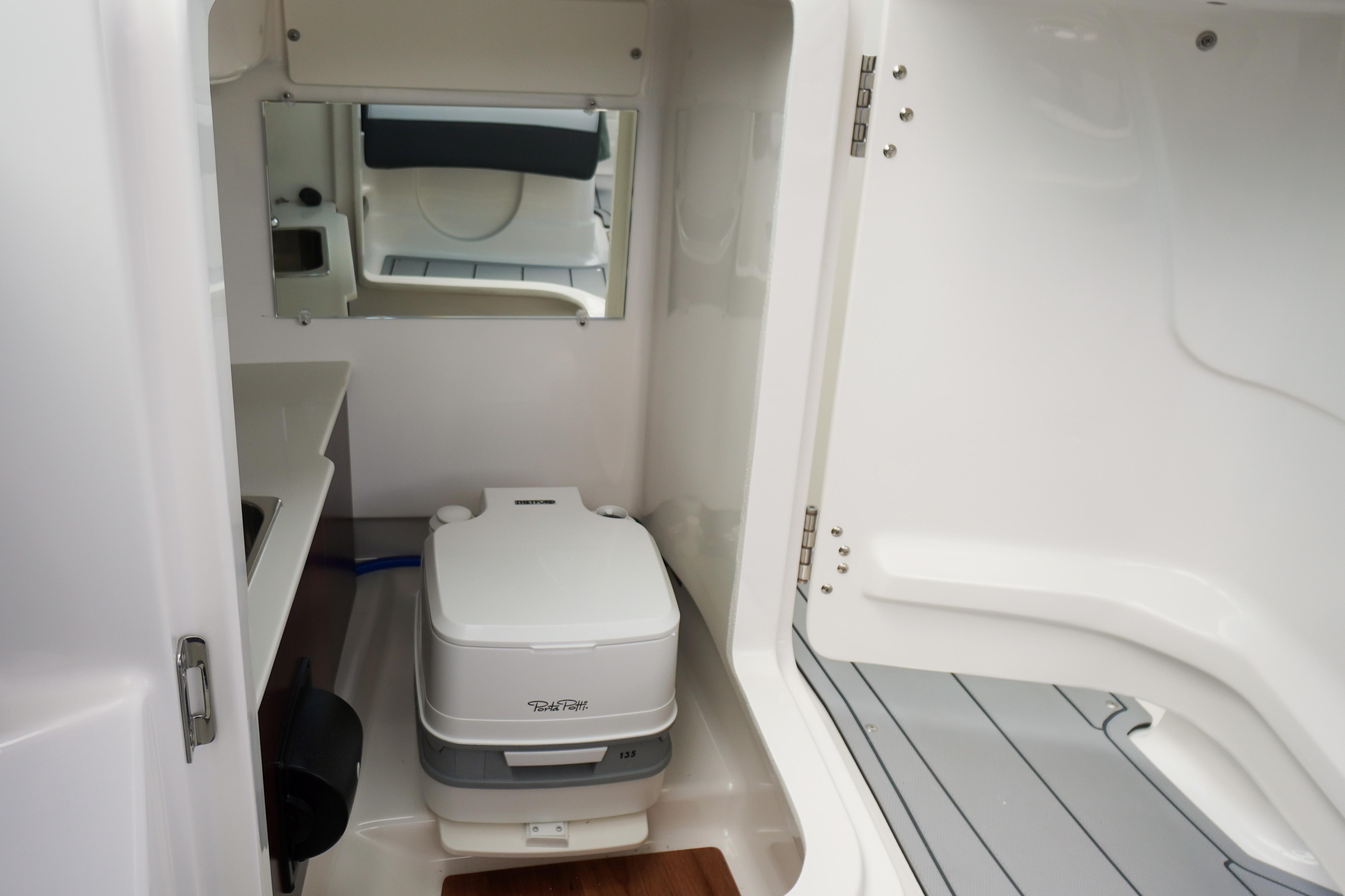 2026 Chaparral SSX 4 boat interior with compact toilet and mirror.