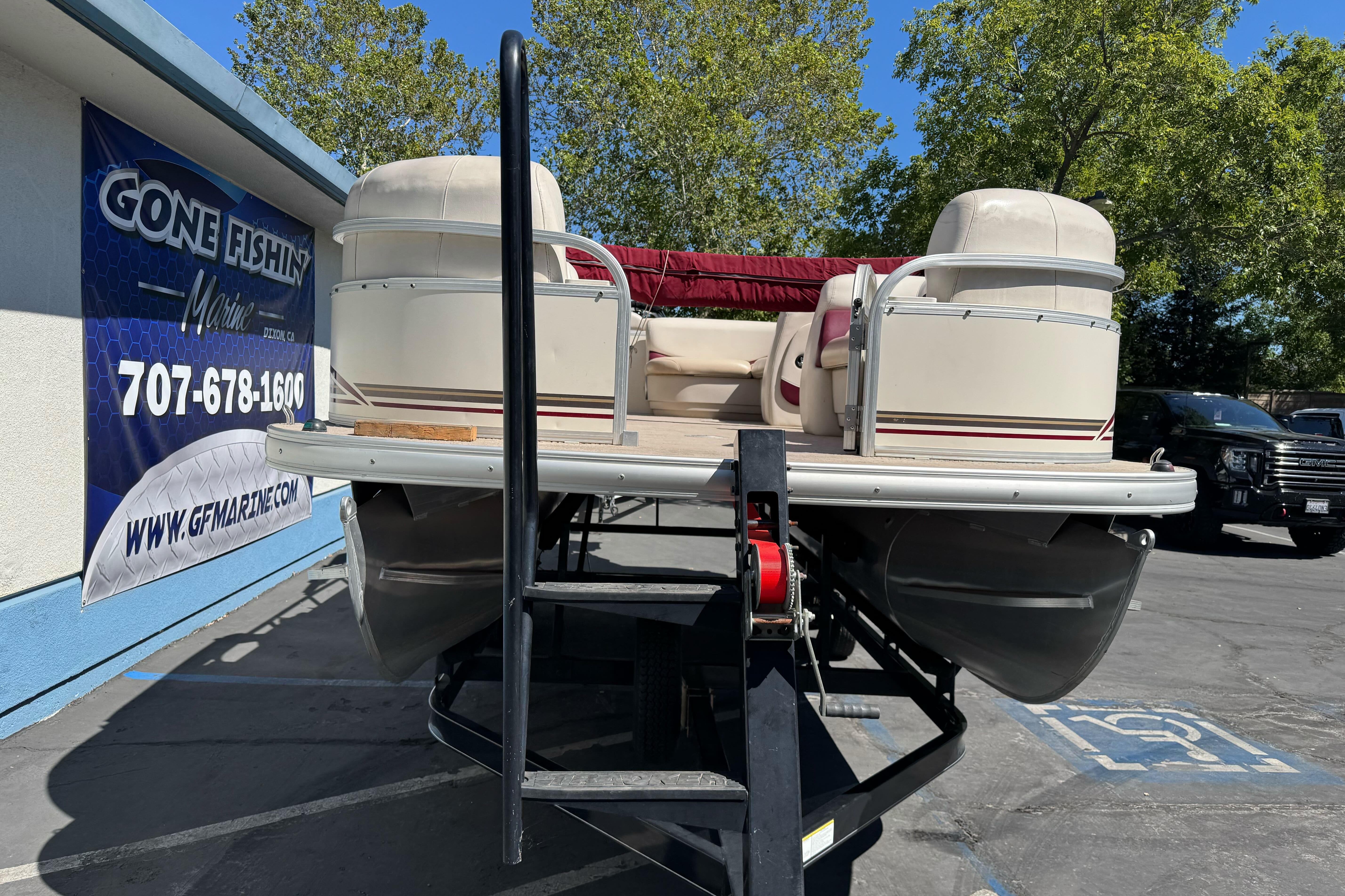 2011 Sun Tracker Party Barge 21 pontoon boat on trailer at dealership.