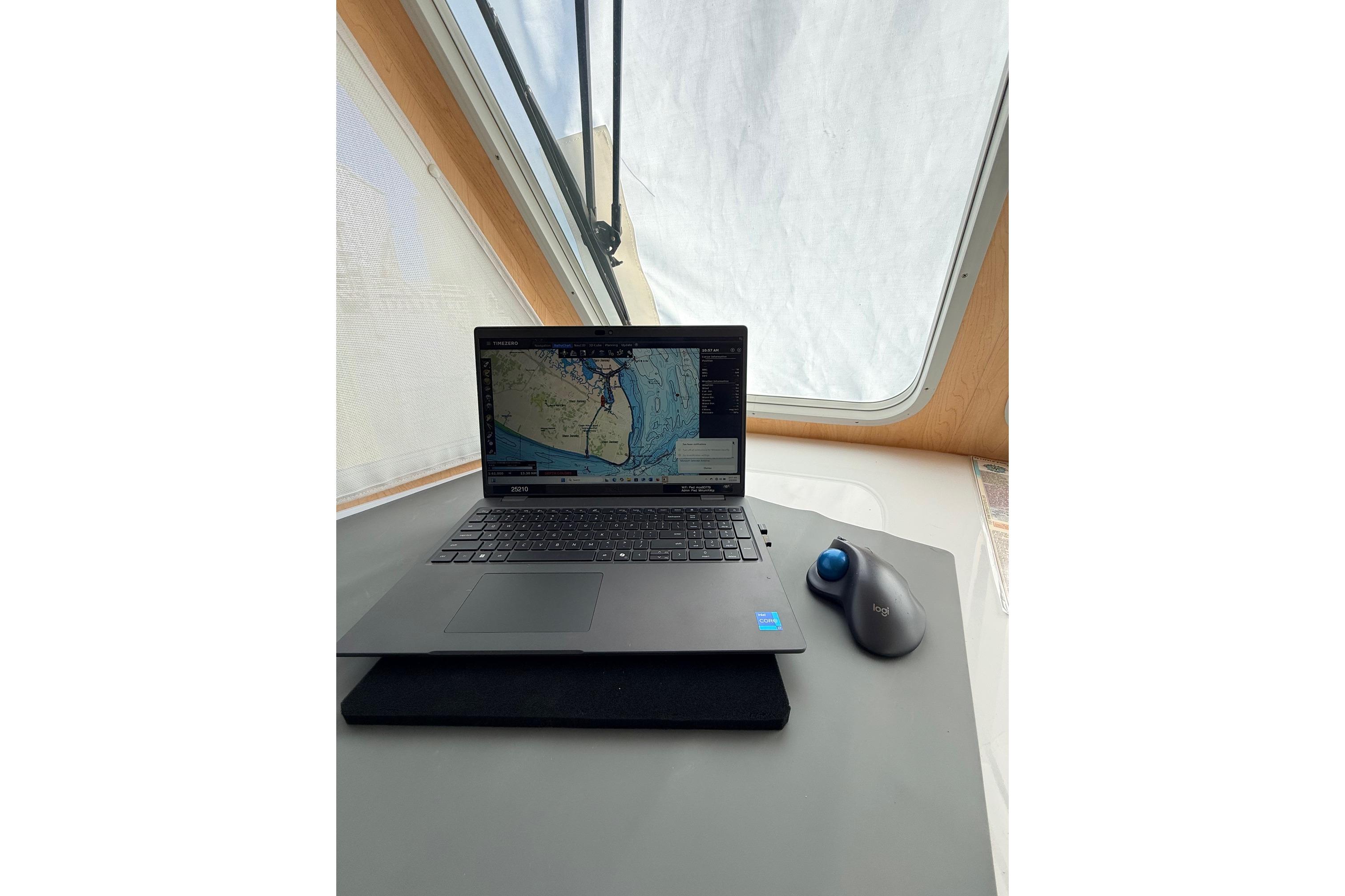 Laptop with navigation software on Wesmac 42 boat, 2025 model, near window.