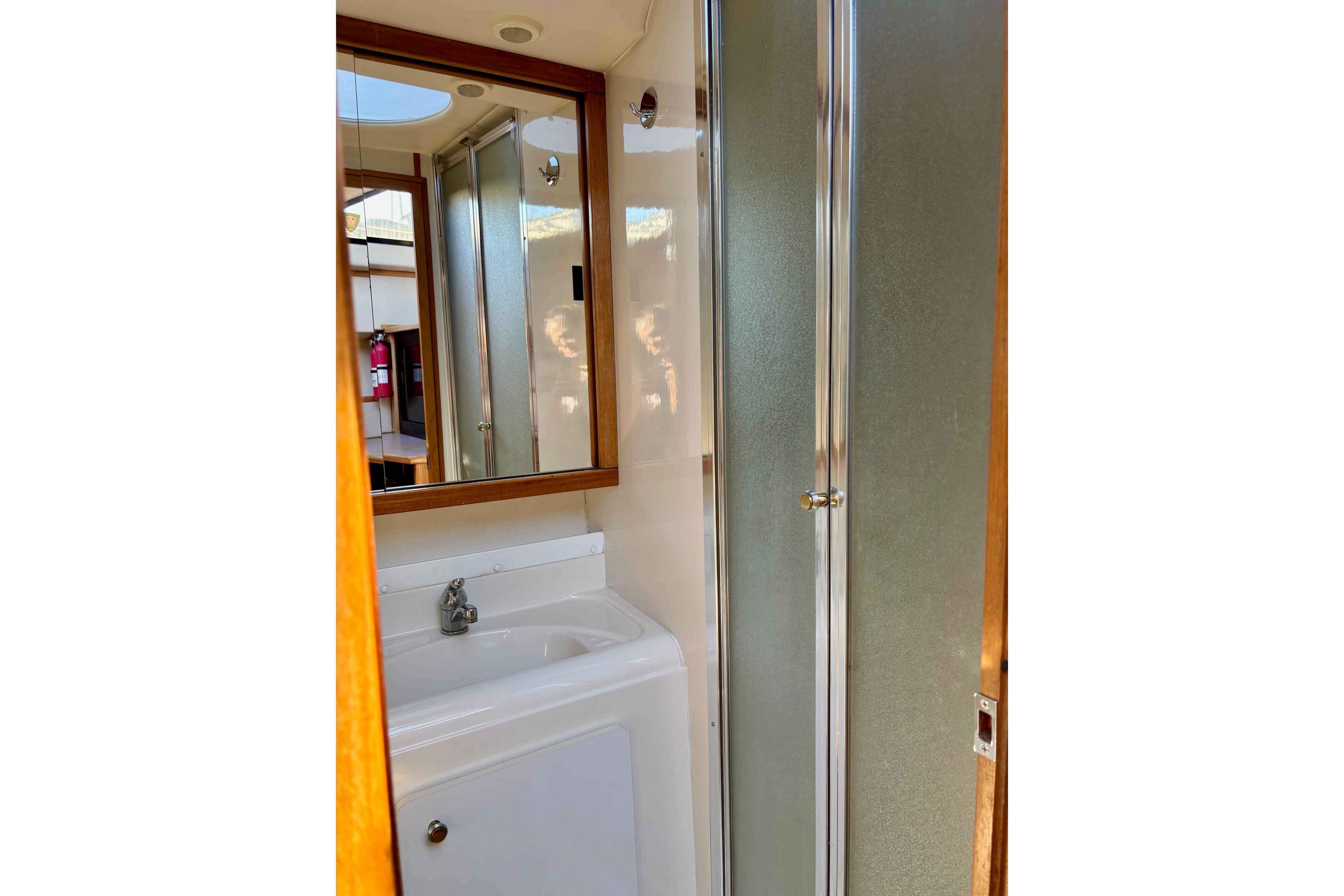 Bathroom interior of 1998 Bayliner 3388 Command Bridge Motoryacht with shower and sink.