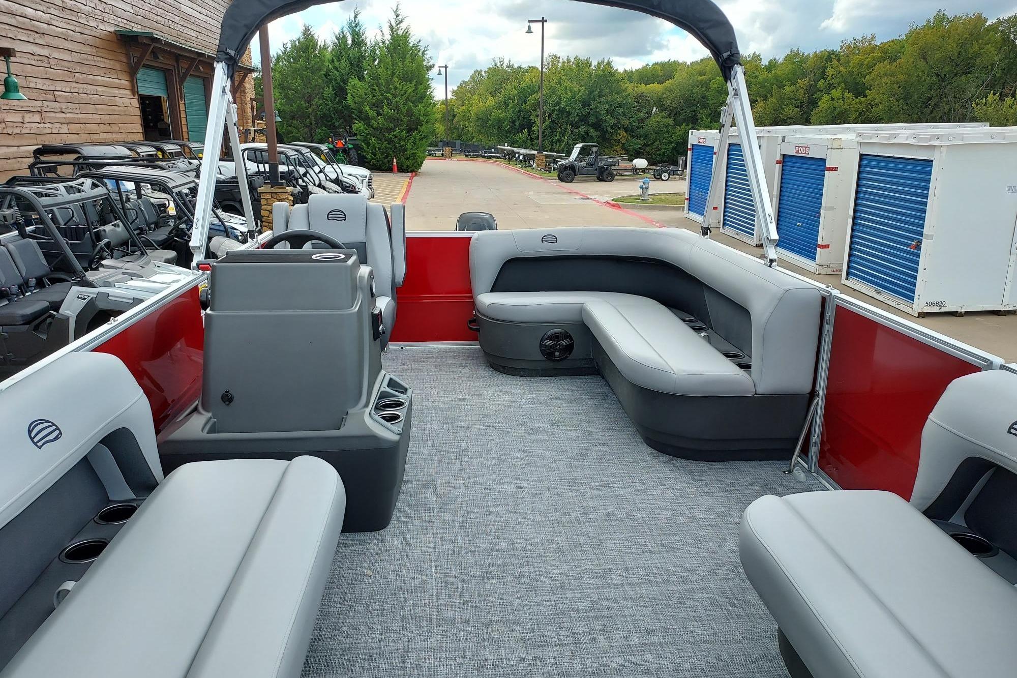 2026 Sun Tracker Party Barge 16 DLX interior with gray seating and red accents.