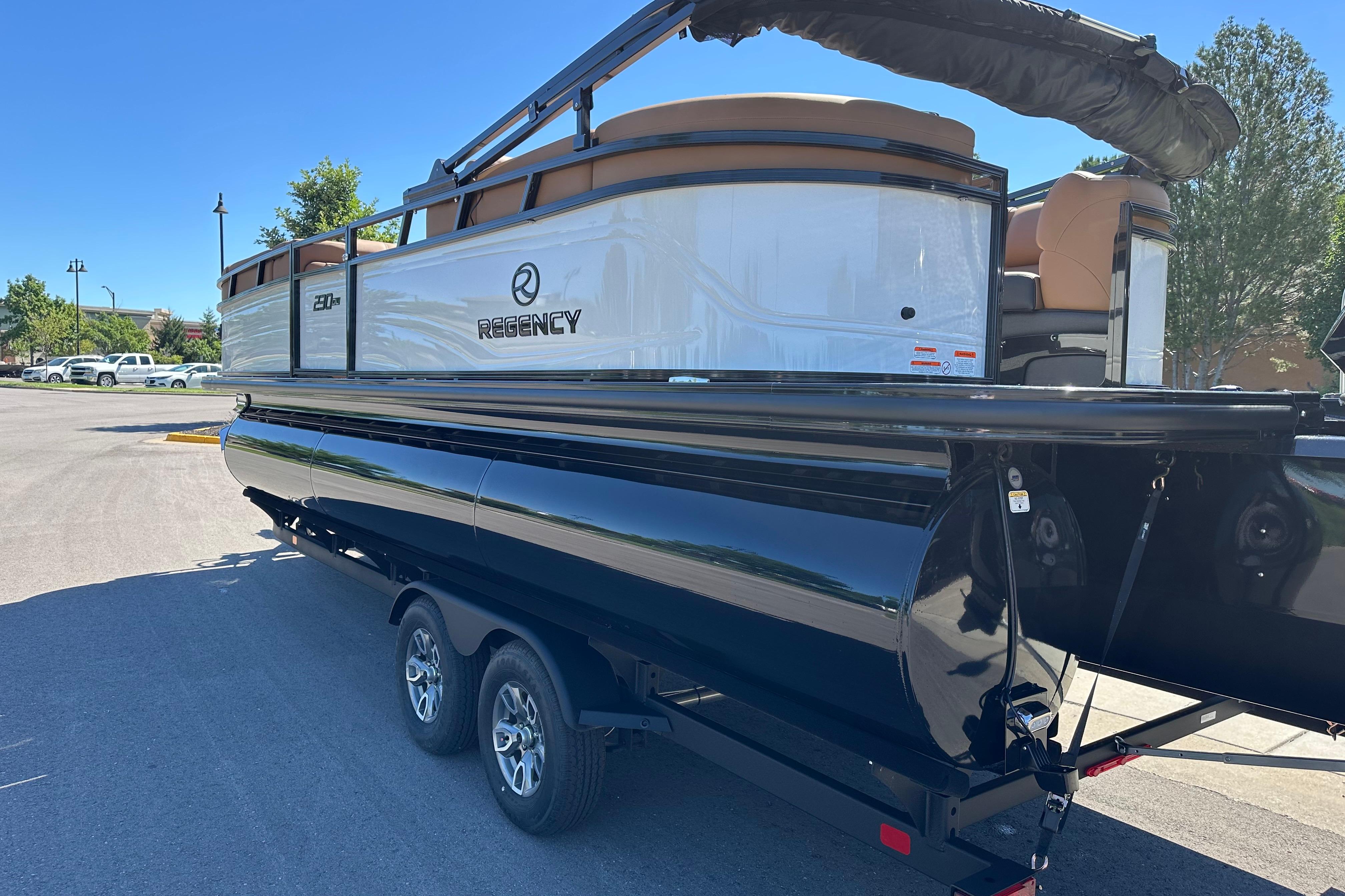 2026 Regency 230 DL pontoon boat on trailer in sunny parking lot.