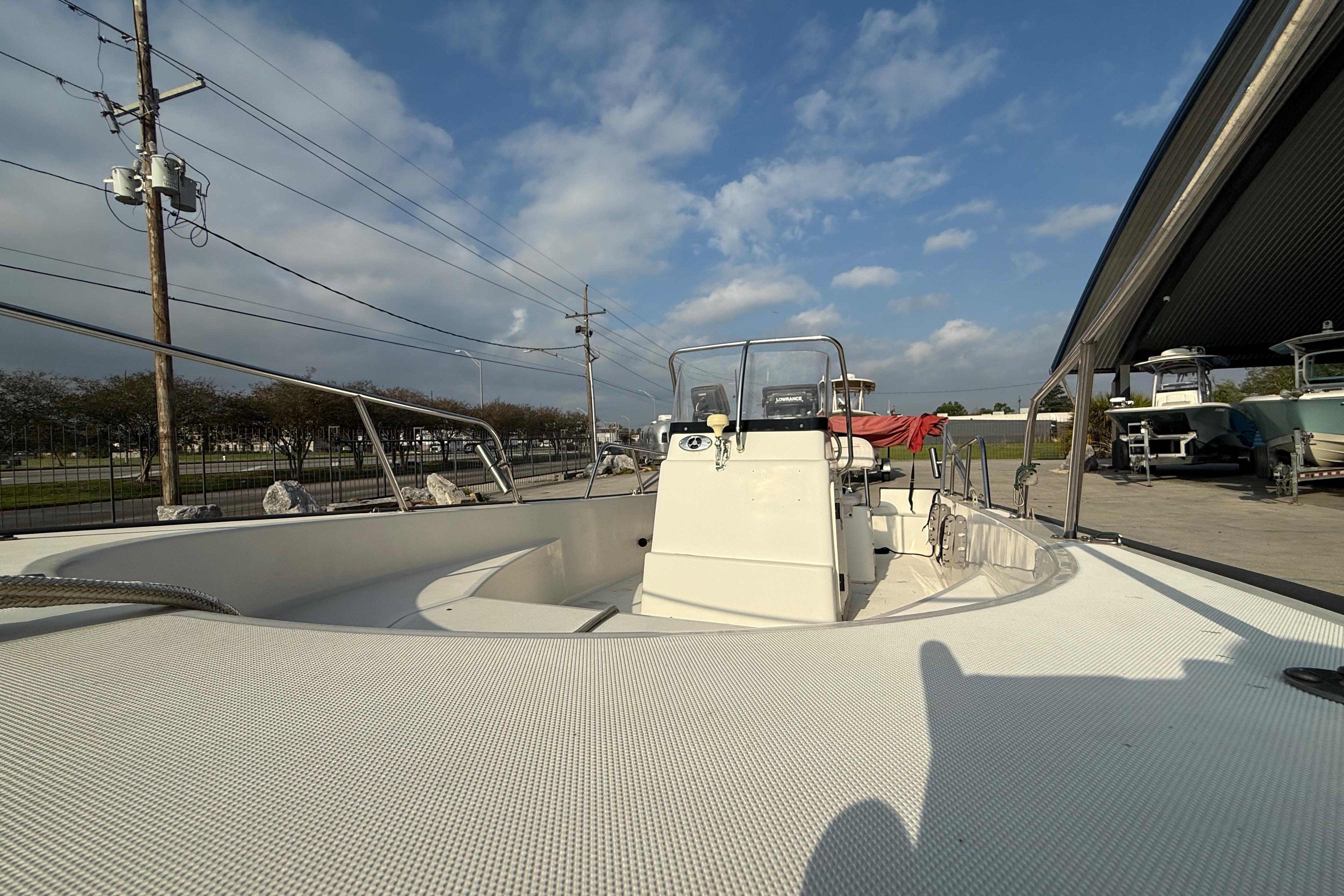 2005 Boston Whaler 17 Montauk boat under a partly cloudy sky at a marina.