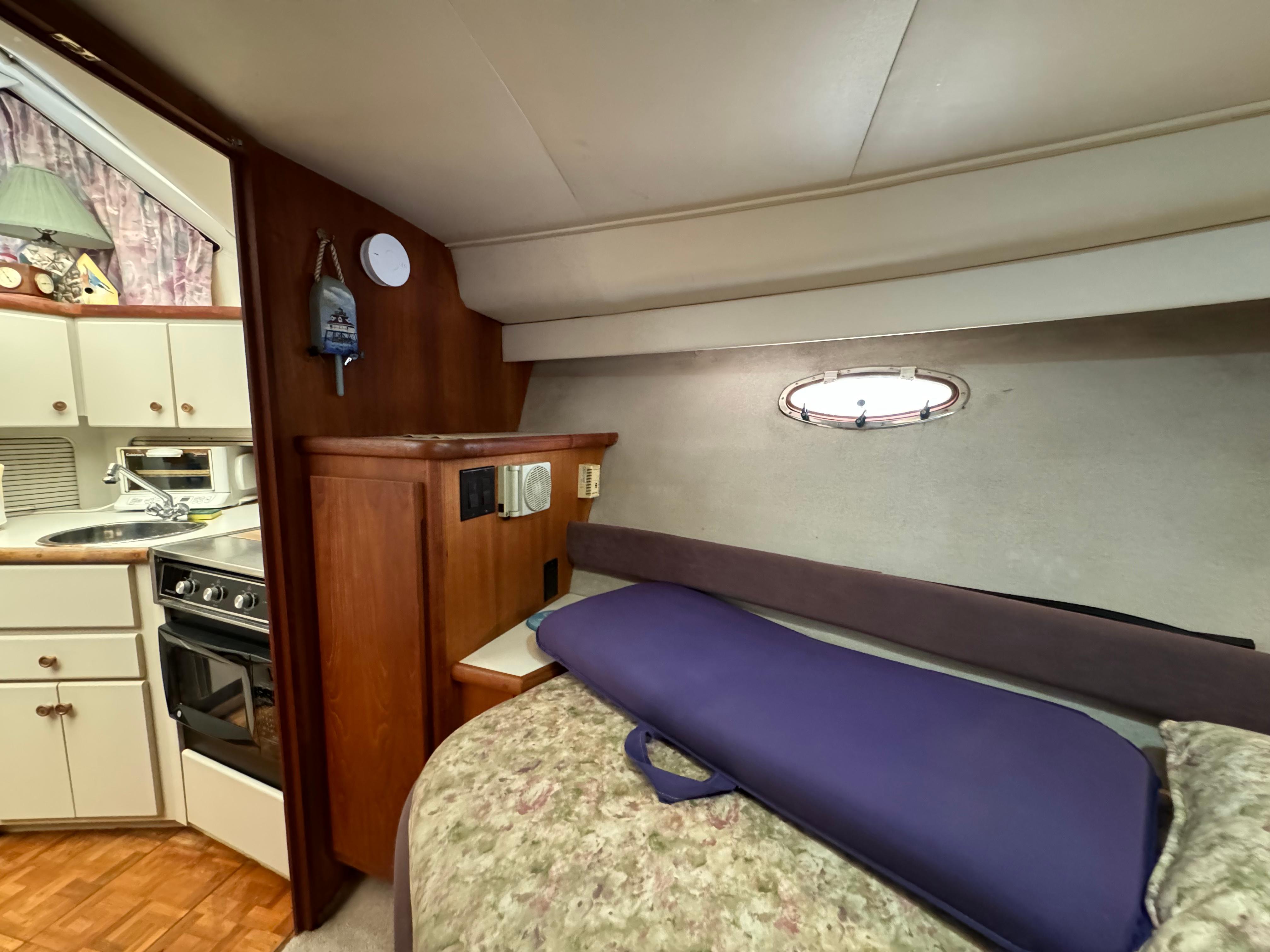 1991 Carver 33 Aft Cabin interior with cozy bed, kitchenette, and wood accents.