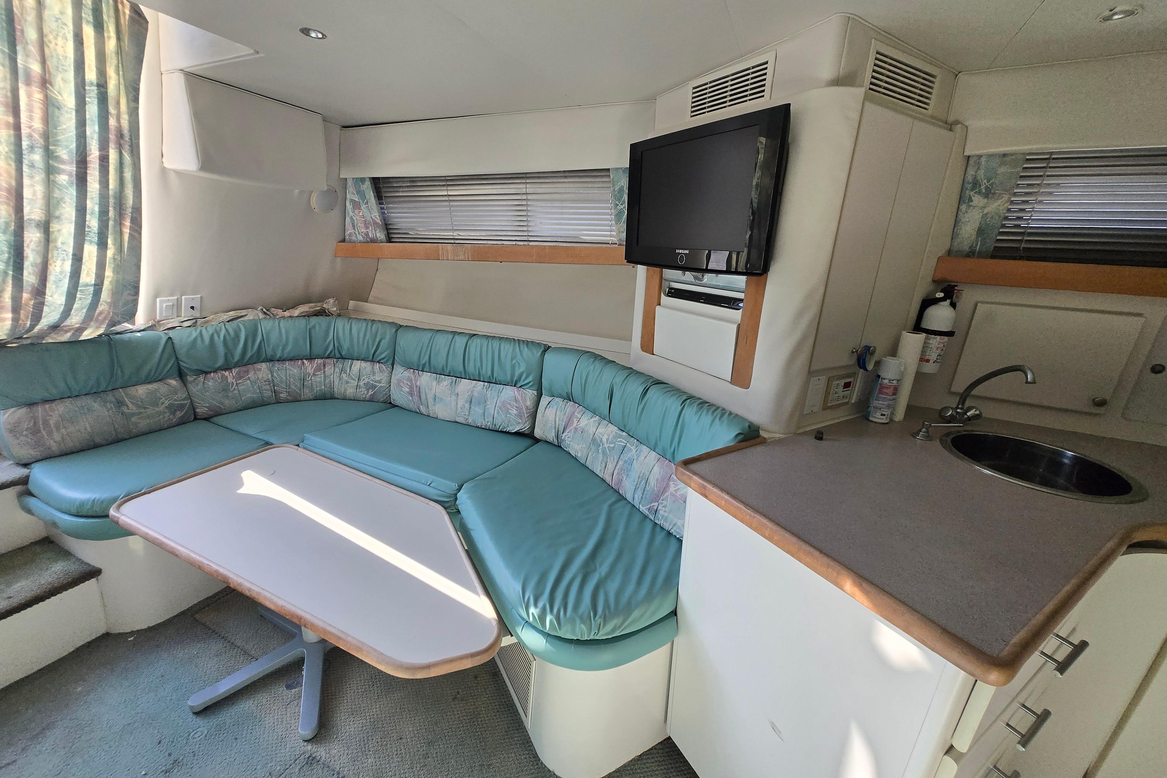 Interior of 1994 Carver 380 Santego yacht with seating, table, and kitchenette.