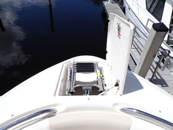 2011 Chaparral 287 SSX boat with open bow storage and ladder, docked by the water.