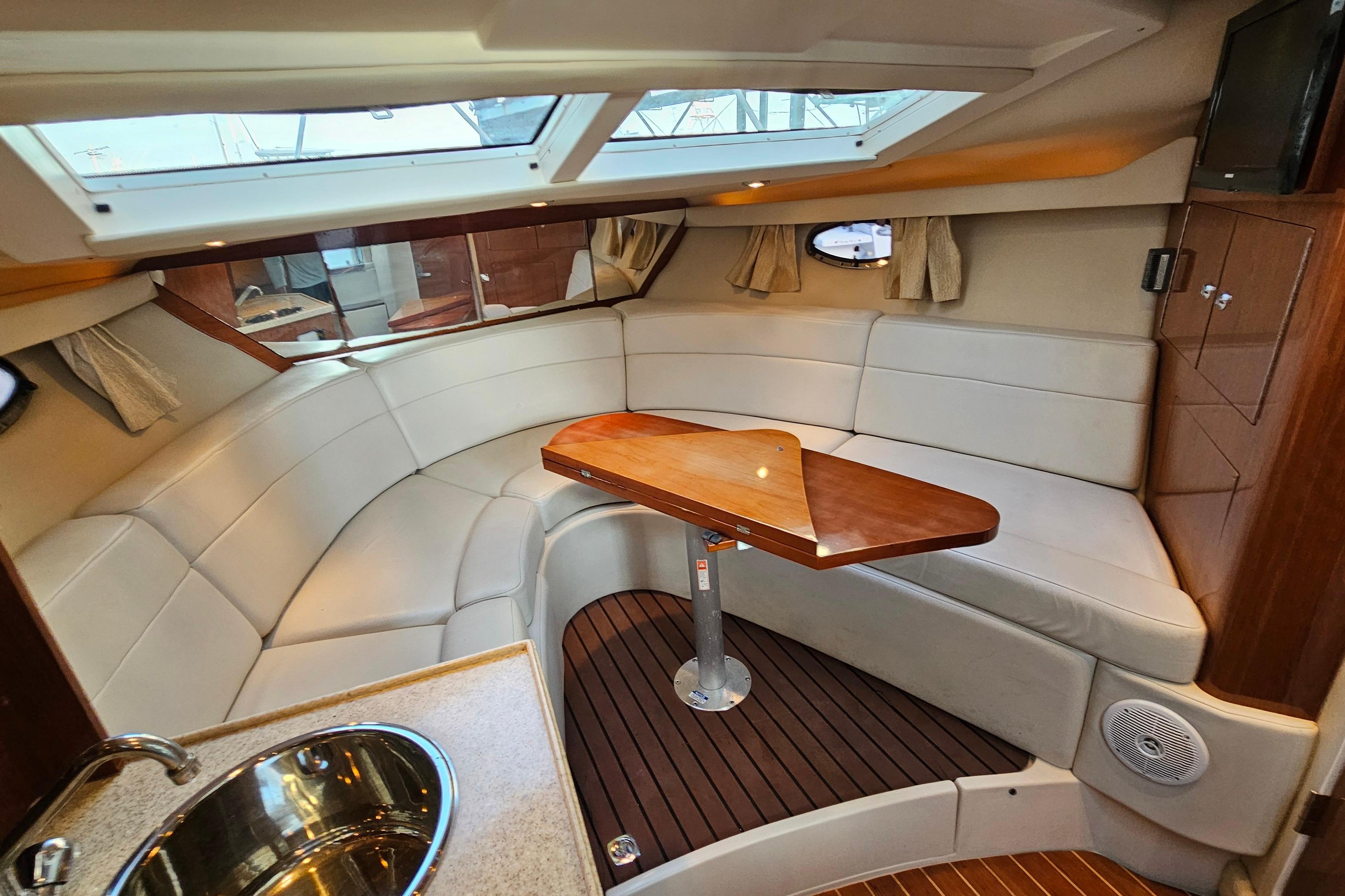 2005 Regal 3060 Window Express cabin with plush seating and wooden table.