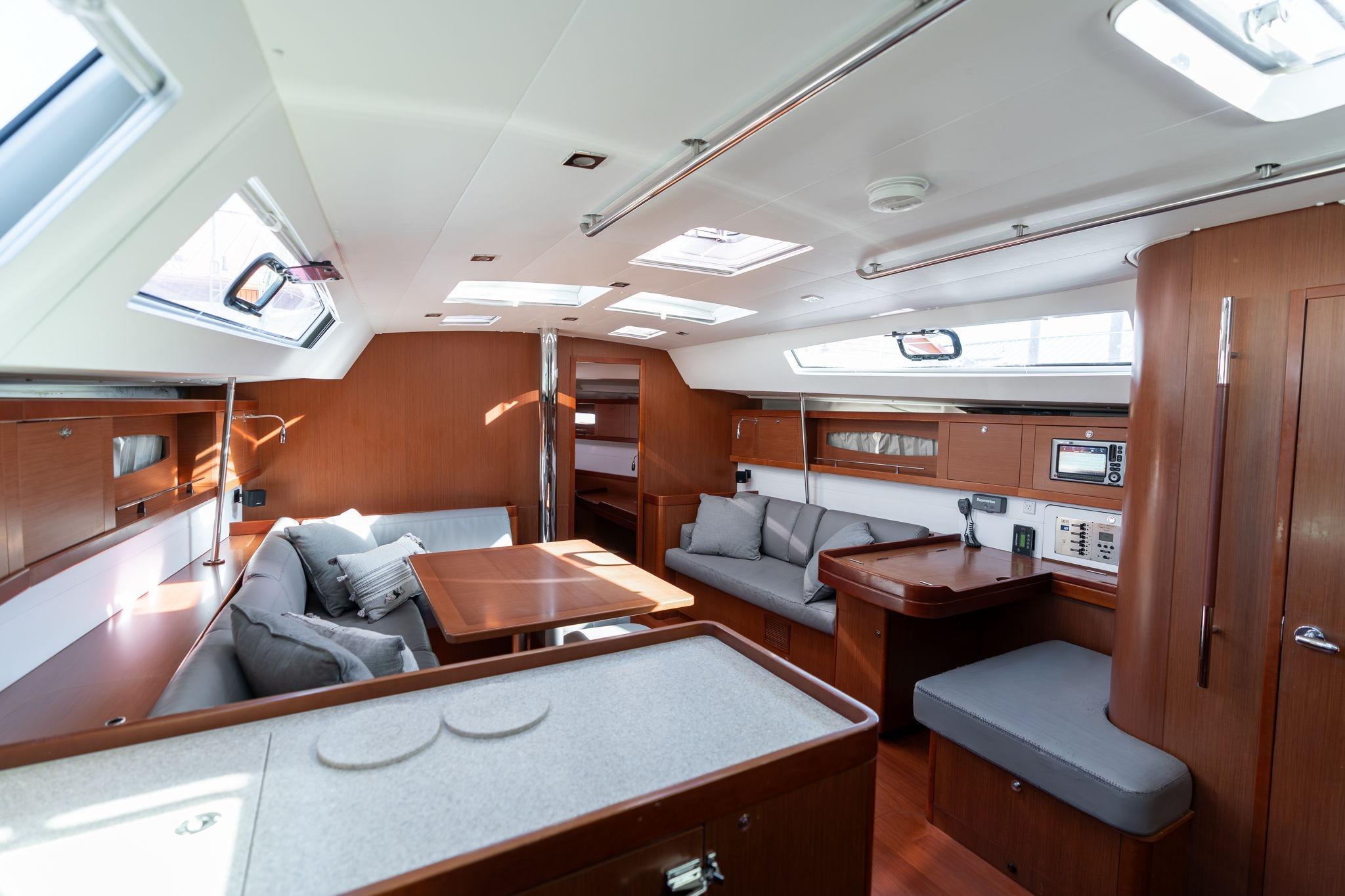 Interior of 2013 Beneteau Oceanis 50 yacht, featuring modern wood finish and spacious seating.