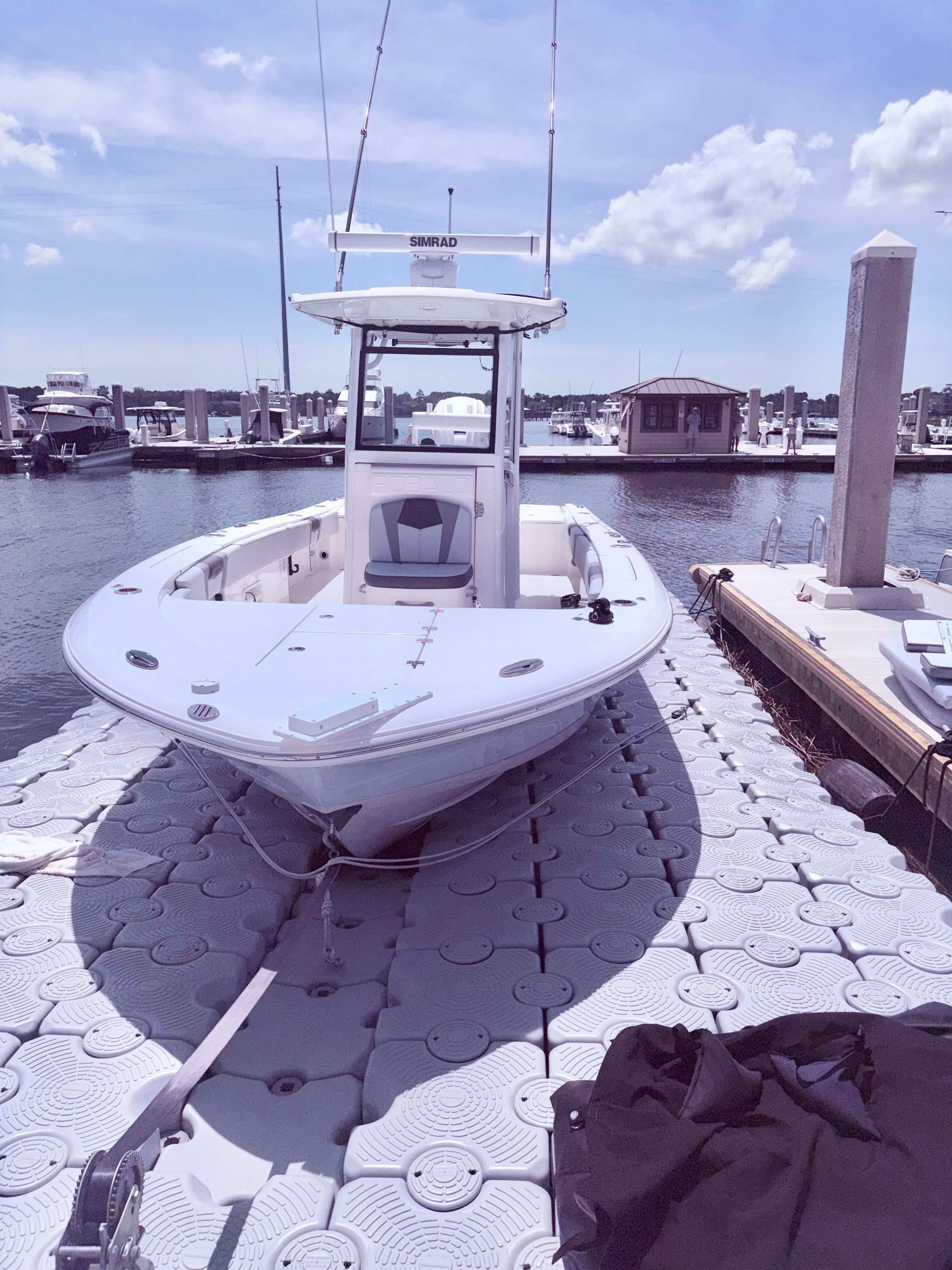 2025 Robalo 266 Cayman boat docked on floating platform.