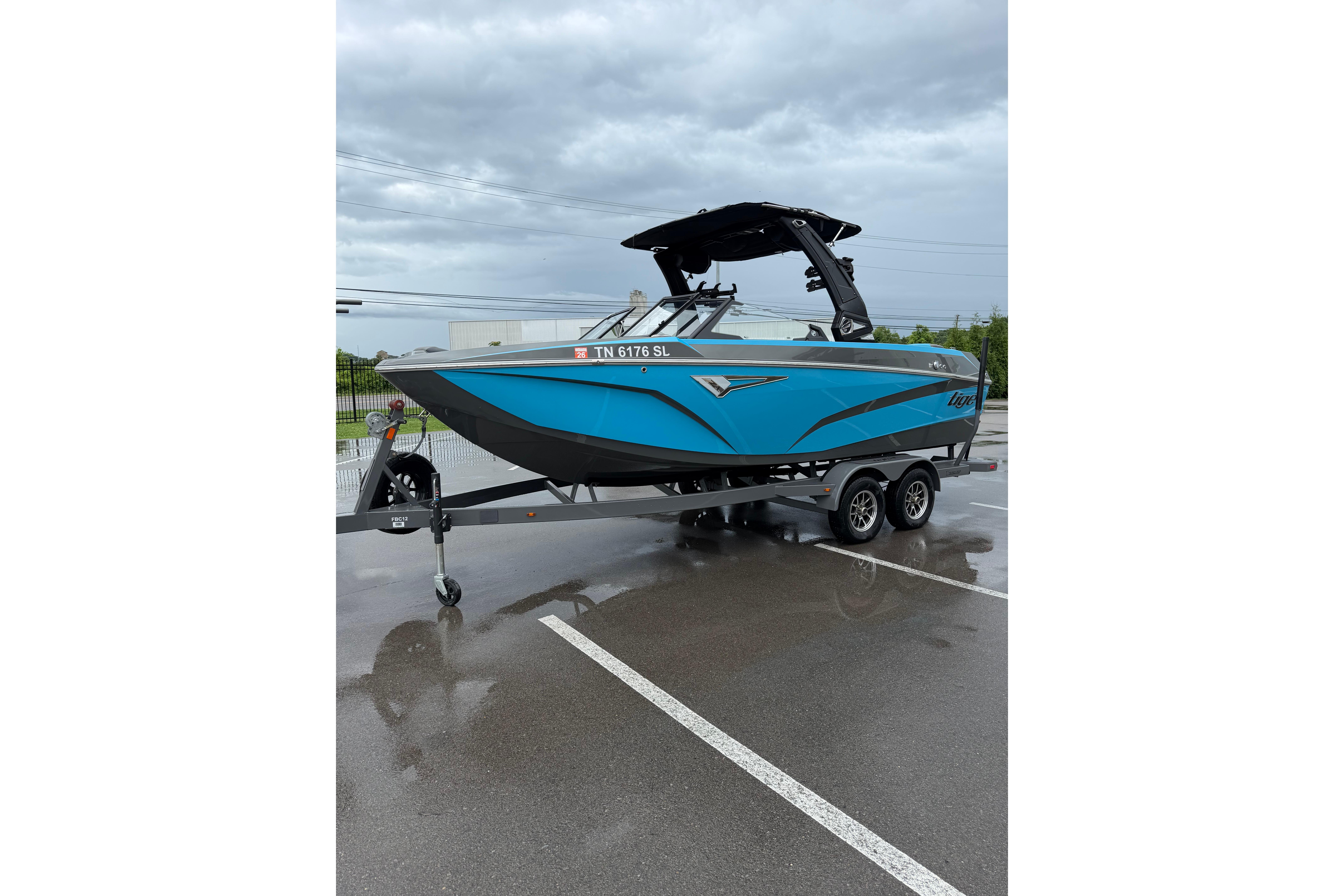 2023 Tigé Z1 boat in blue on a trailer, parked in a wet lot.