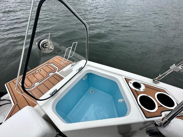 2025 Starcraft SVX 211 OB CC boat with open hatch and cup holders on deck.