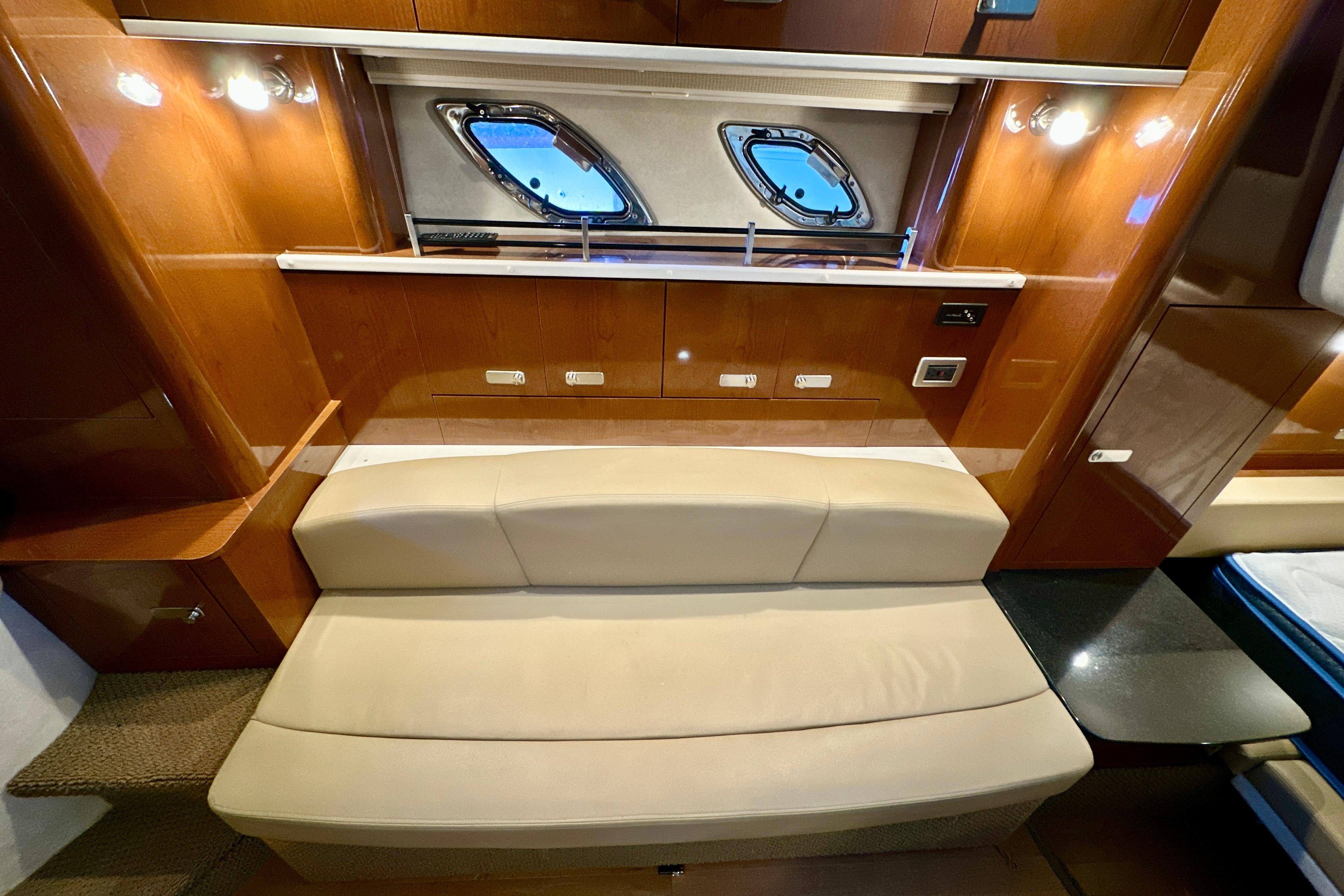 Interior of 2012 Sea Ray 330 Sundancer with beige seating and wooden cabinetry.