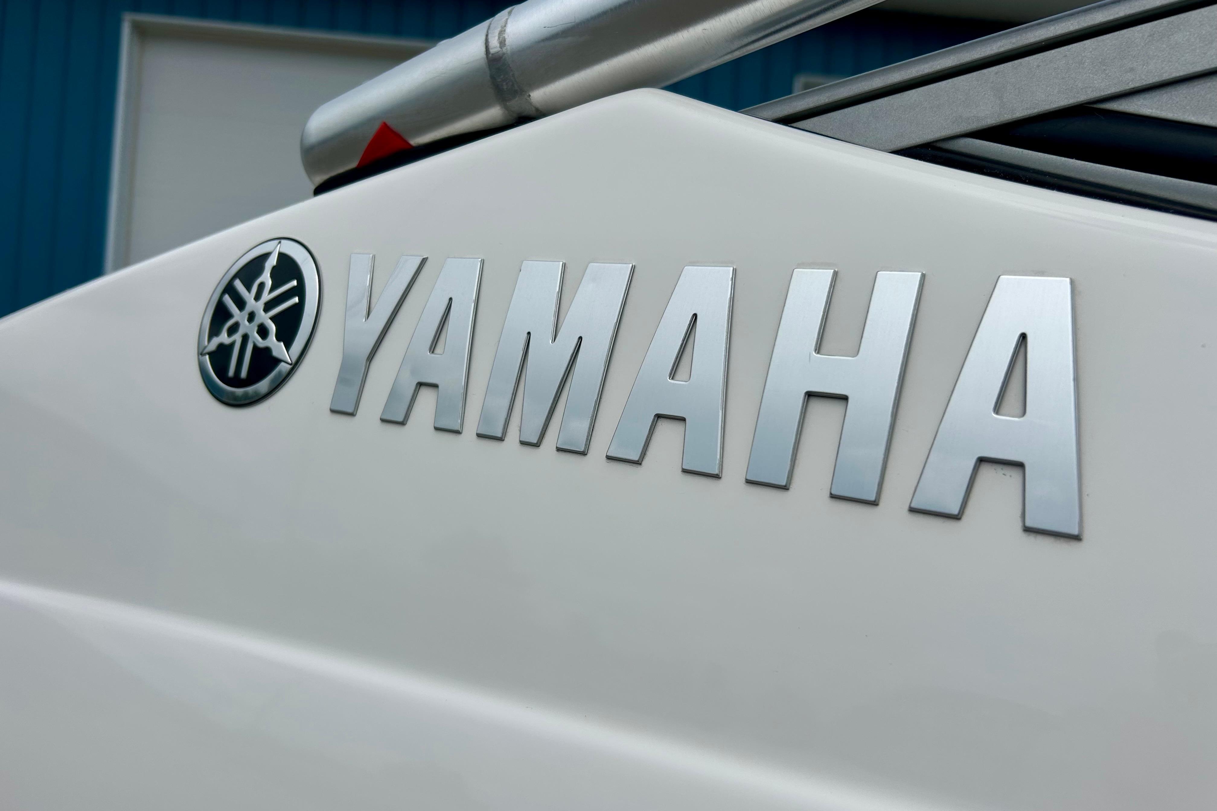 Close-up of 2015 Yamaha AR210 boat logo on white surface.