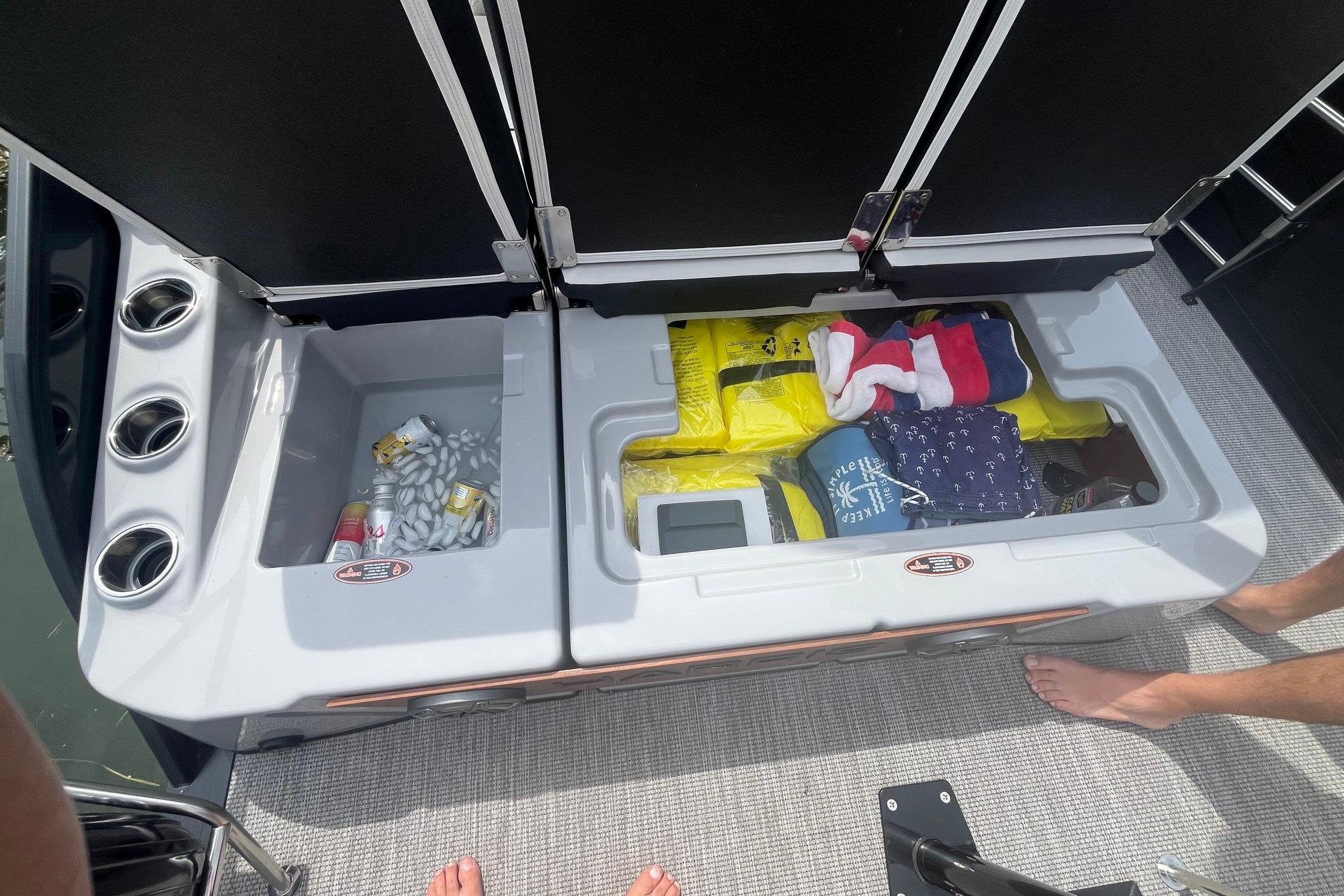 Storage compartments on a 2024 Harris Grand Mariner 250 boat, filled with supplies and accessories.