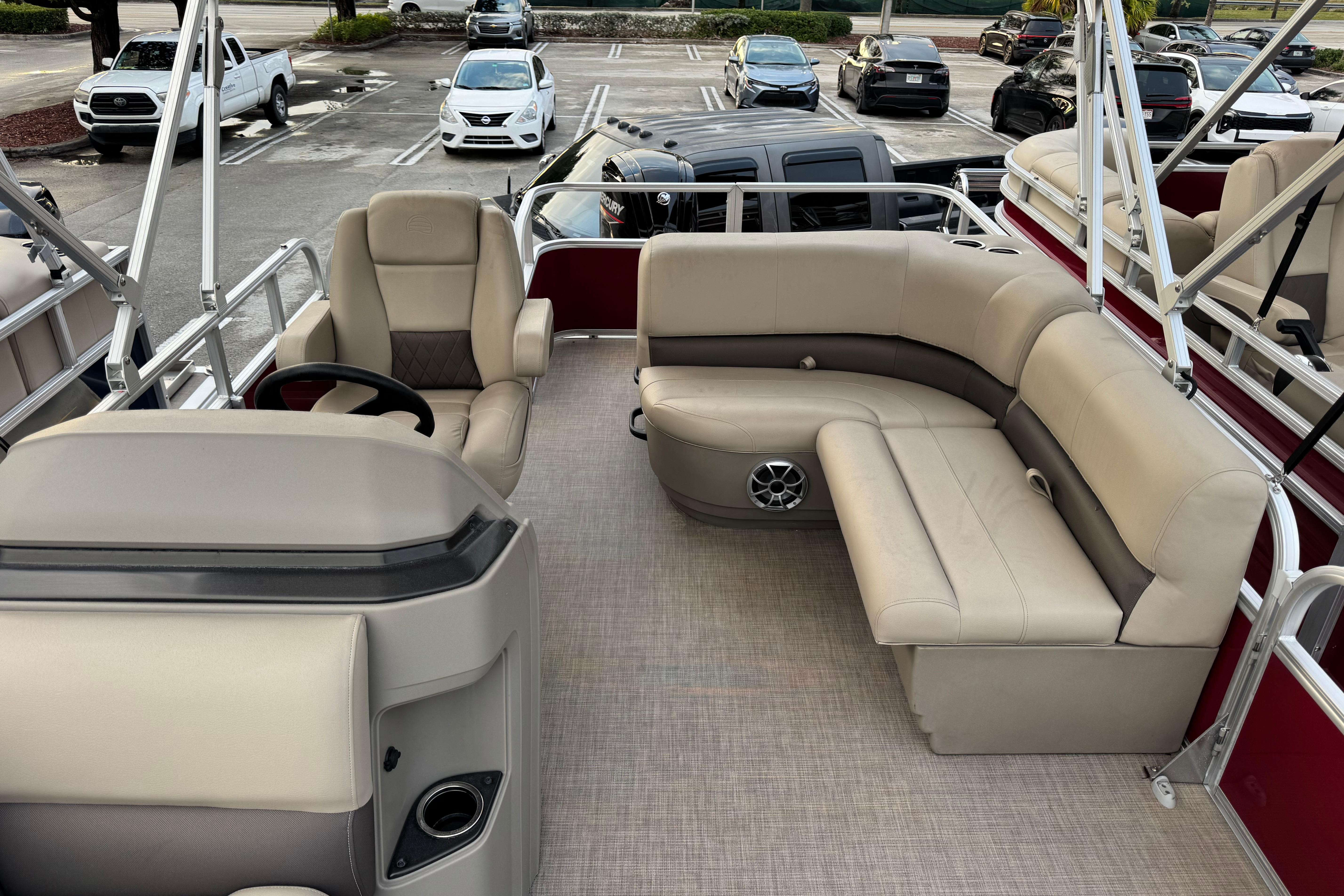2025 Sun Tracker Party Barge 18 DLX interior with beige seating and steering console.
