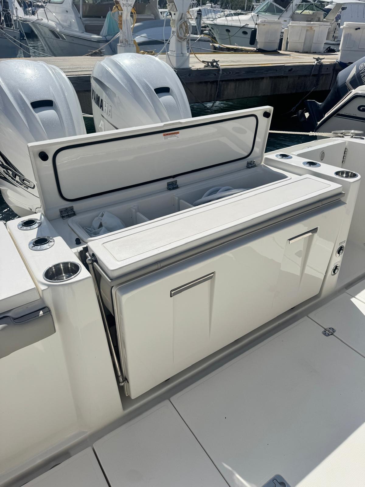 2023 Pursuit S 358 Sport boat with open storage compartment and twin engines.