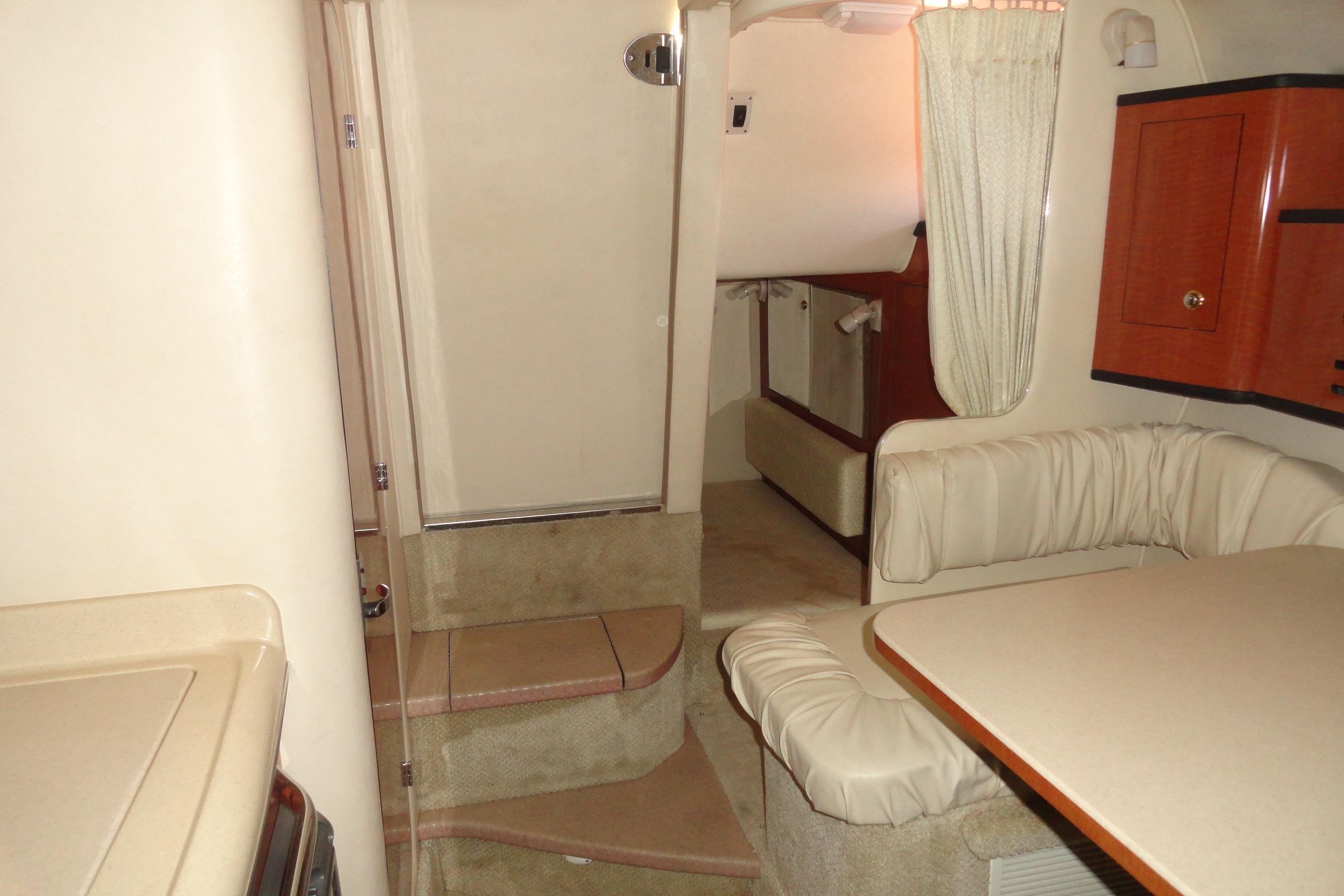 2004 Sea Ray Sundancer 280 cabin interior with seating, table, and stairs.