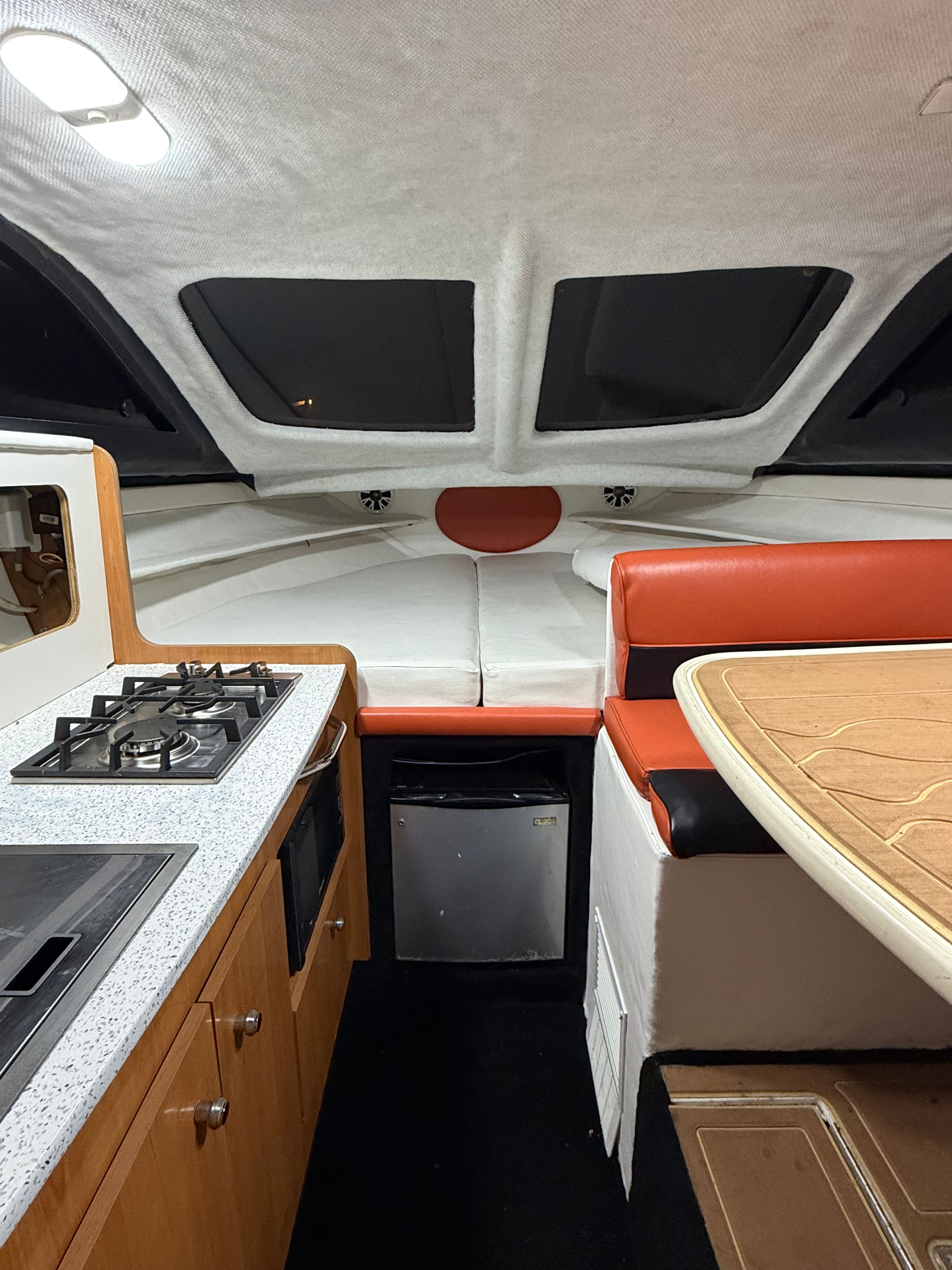 Interior of a 2001 Bayliner 2452 Ciera Classic with kitchen and seating area.