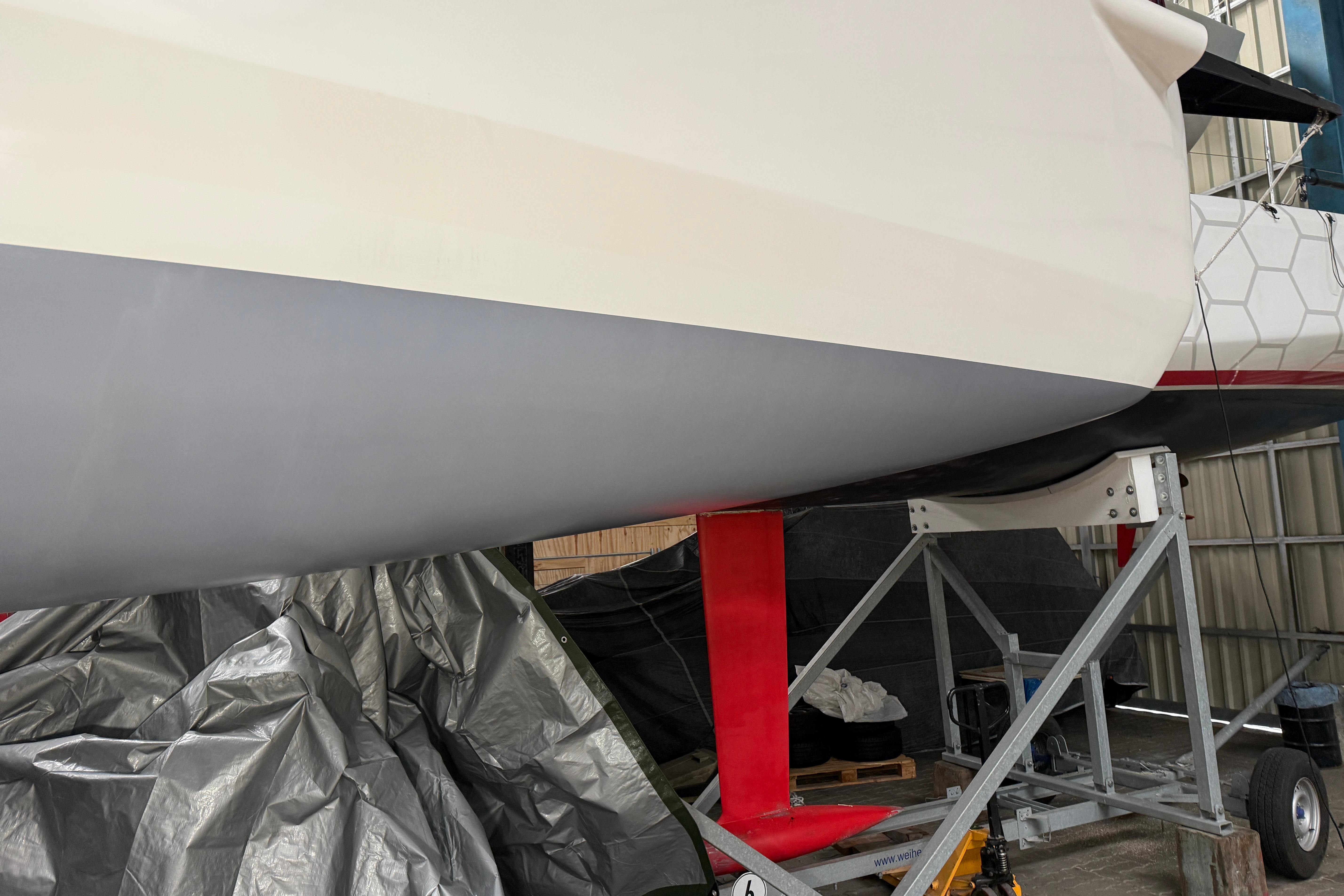Sailboat JPK 1030 (2019) on a trailer in a storage facility.