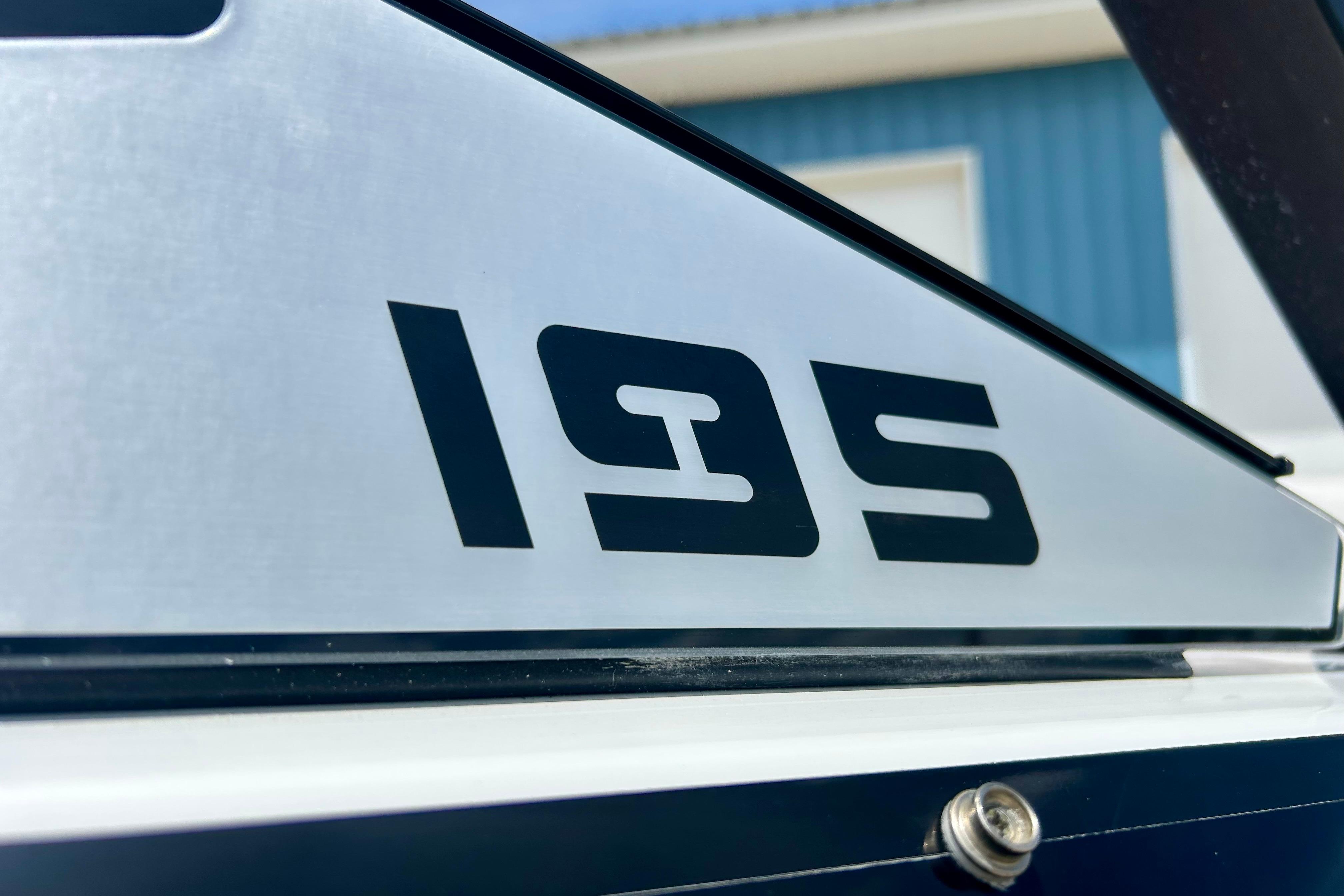 Close-up of 2021 Scarab 195 ID boat model emblem on metallic surface.