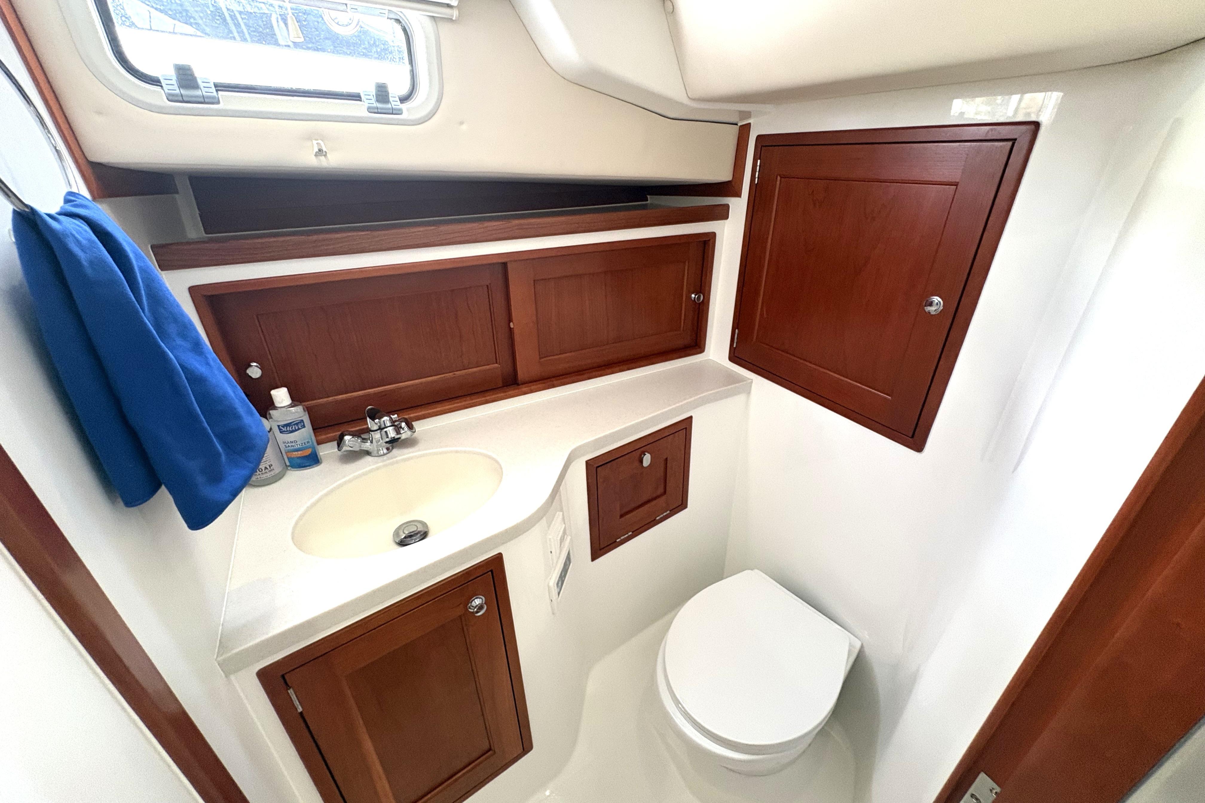 2024 MJM 35z yacht bathroom with wooden cabinets, sink, and toilet.