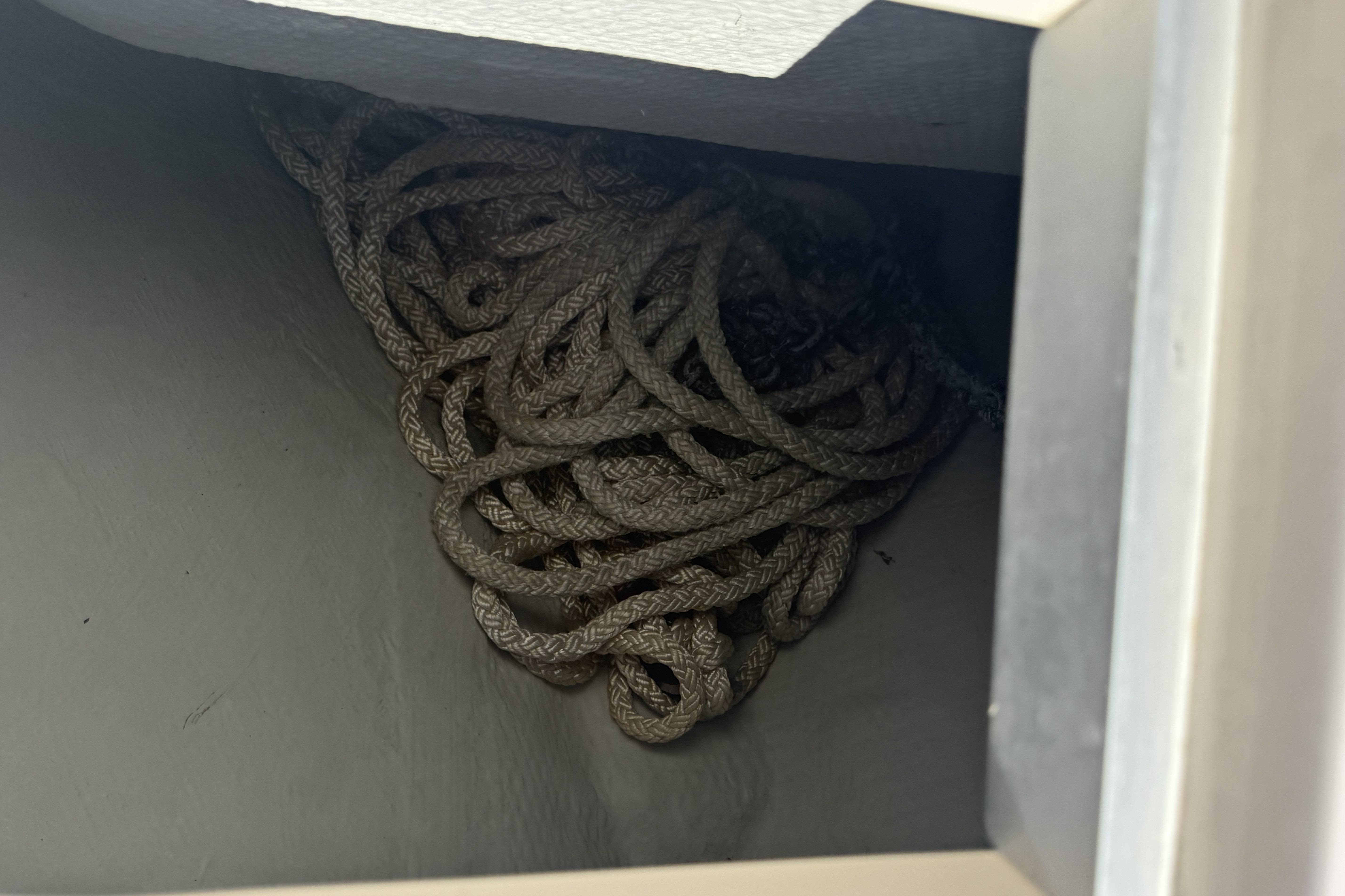 Coiled rope stored in a compartment of a 2014 Grady-White Freedom 275 boat.
