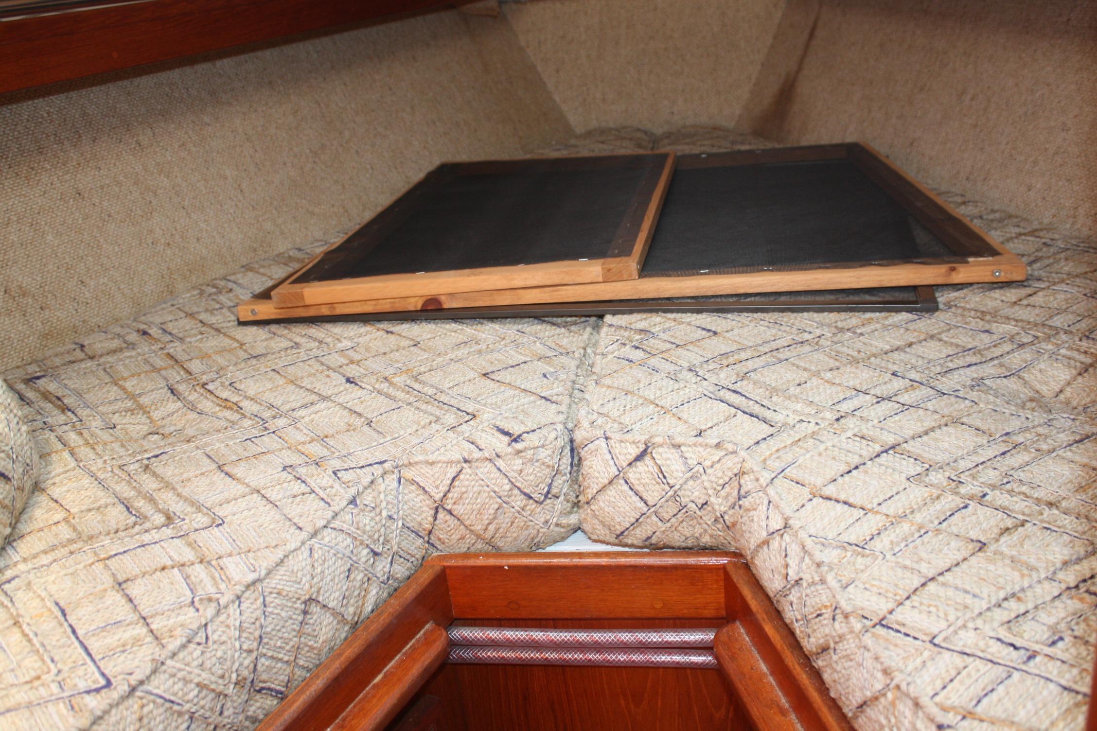 Interior cabin of 1981 S2 9.2A sailboat with patterned cushions and wooden accents.