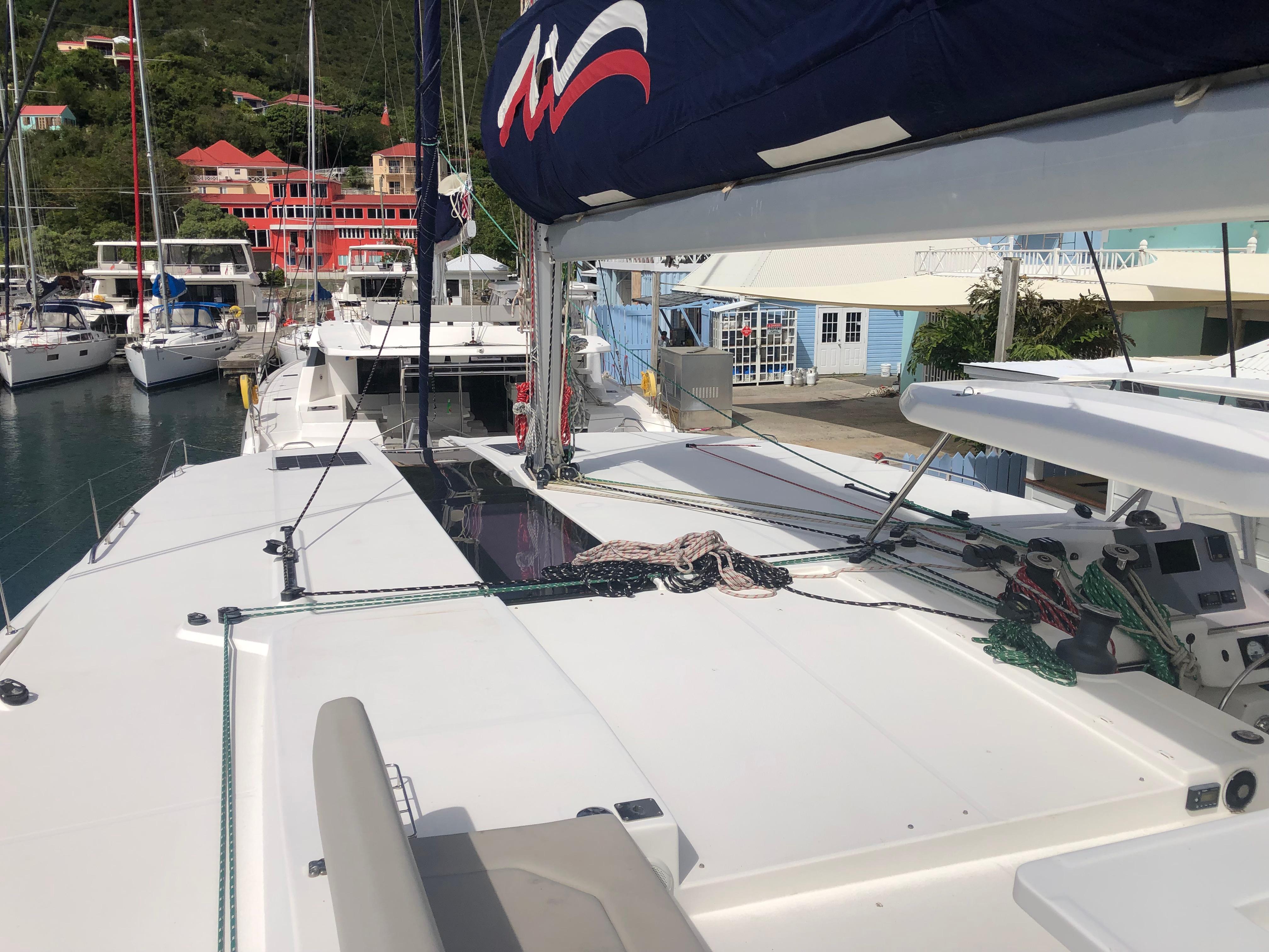 Sailing yacht Leopard 50, 2020 model, docked at a marina with colorful buildings.