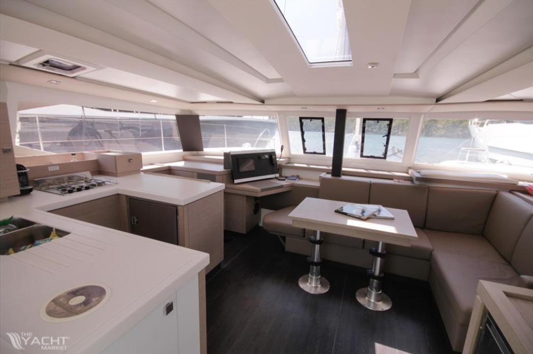 Luxurious interior of 2023 Fountaine Pajot Catamaran Astrea 42 with modern kitchen and seating area.