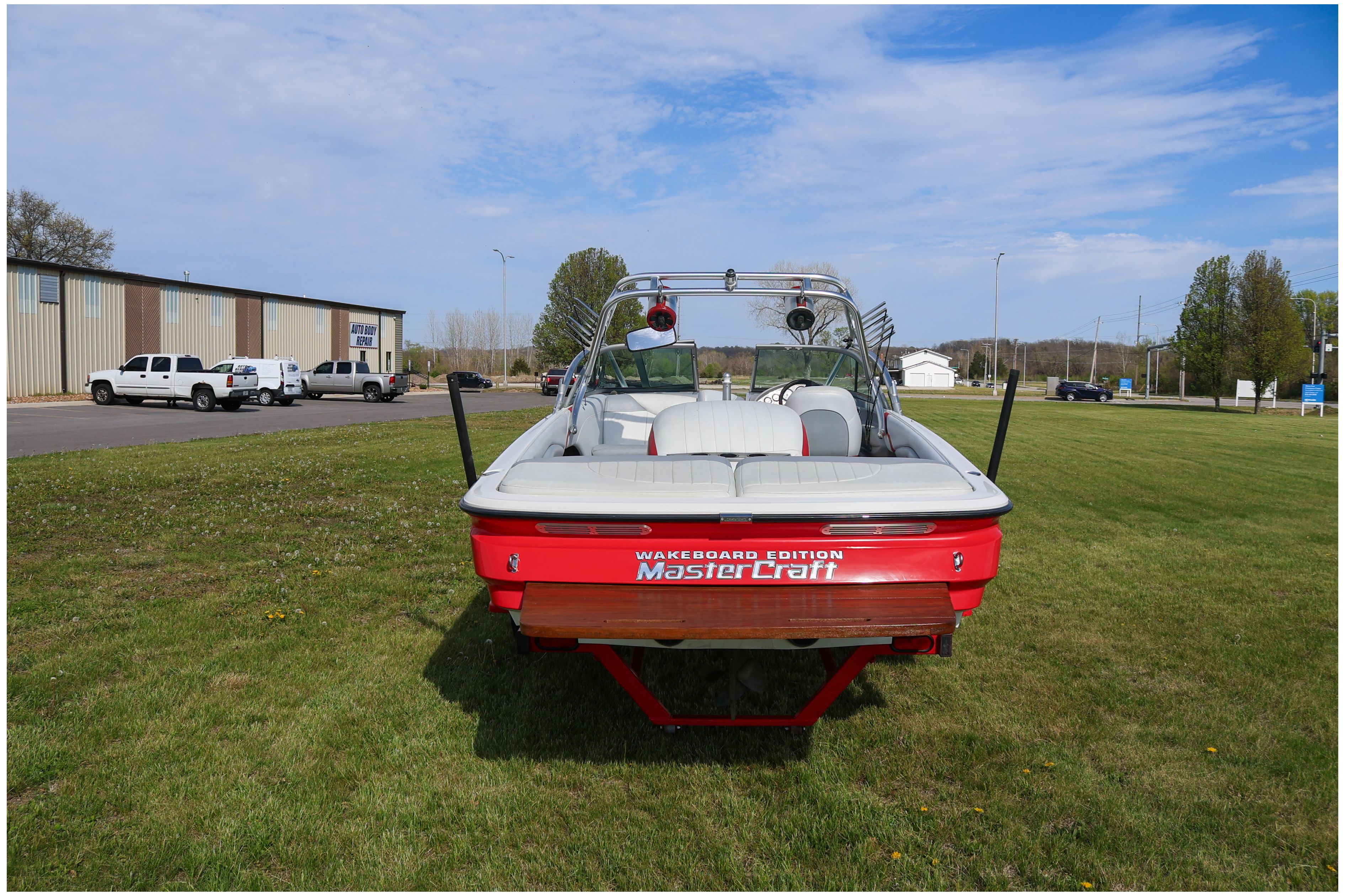 2002 MasterCraft X-7 wakeboard boat parked on grass.